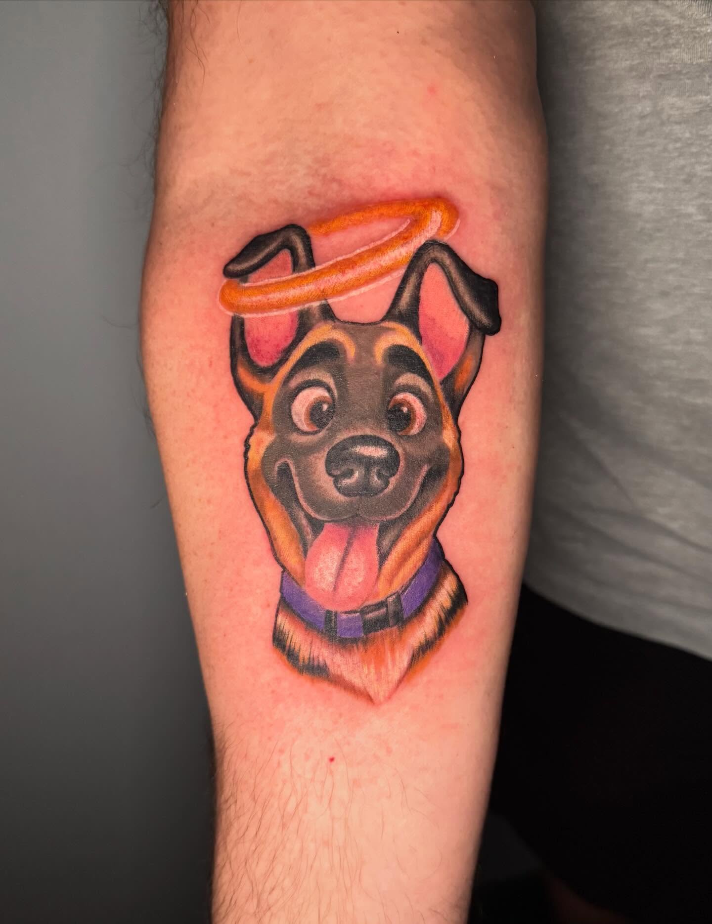 Dog with halo American traditional tattoo on the forearm by Paul Hicks