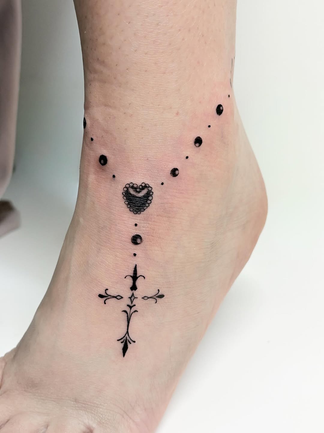 Rosary beads with cross and heart ornamental tattoo on the foot by Jinz