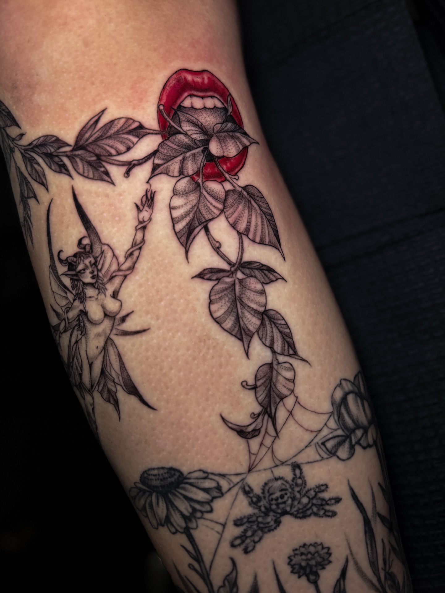 Lips and leaves black and grey tattoo on the forearm by Cristen Aro