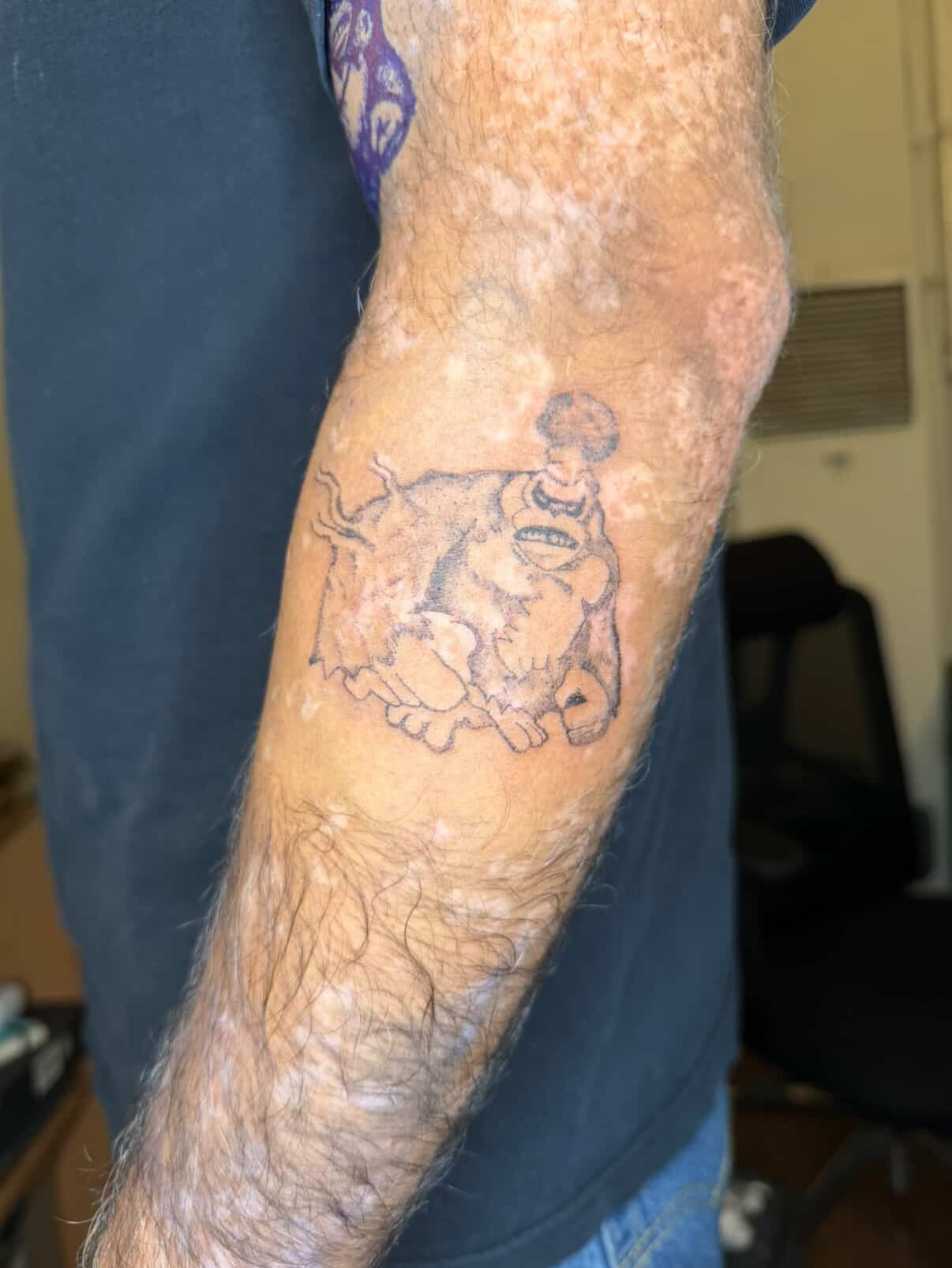 Man with tattoo black and grey tattoo on the forearm by Swag Originator