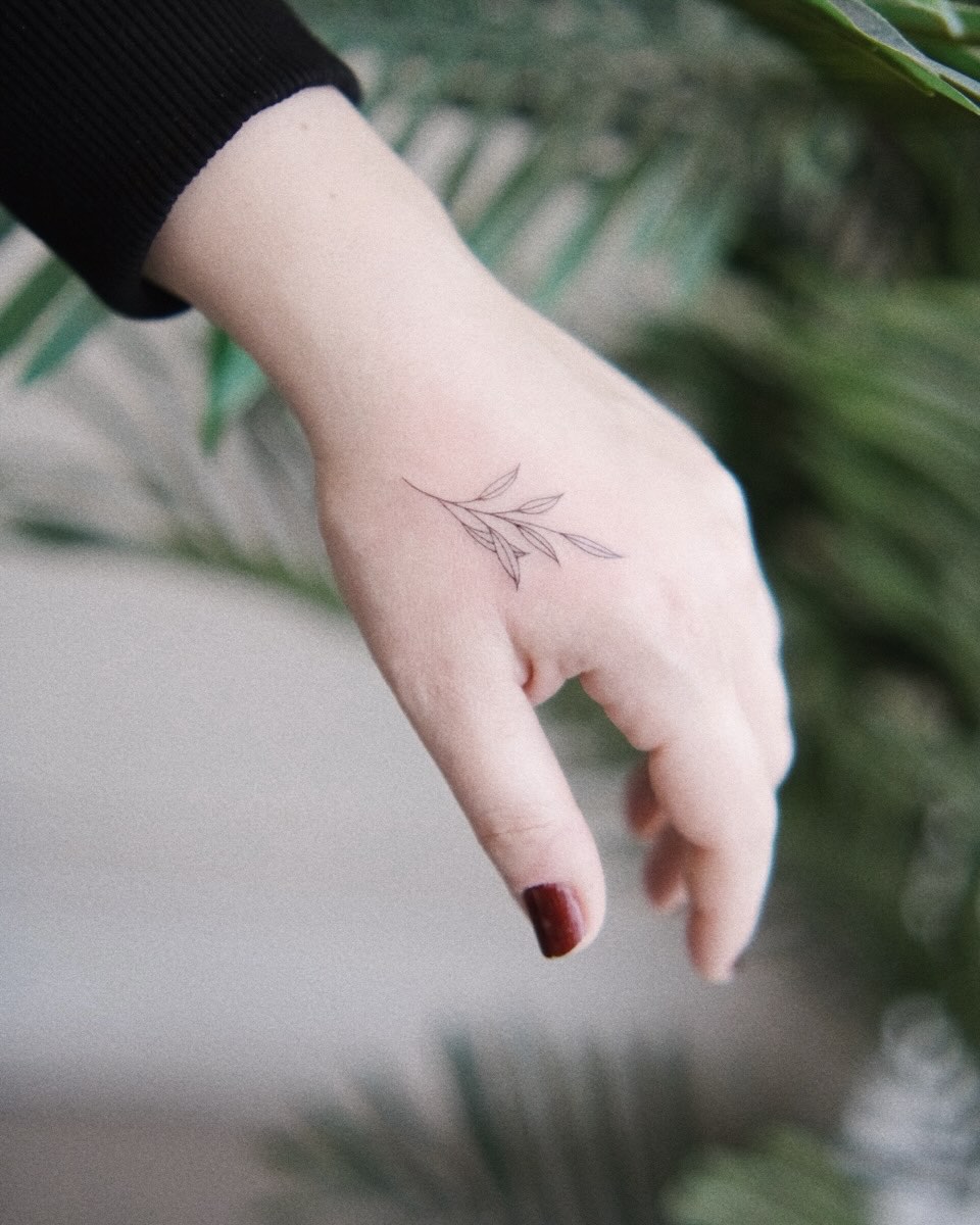 Branch with leaves fine line tattoo on the hand by ginn ❀ fine line tattoo artist