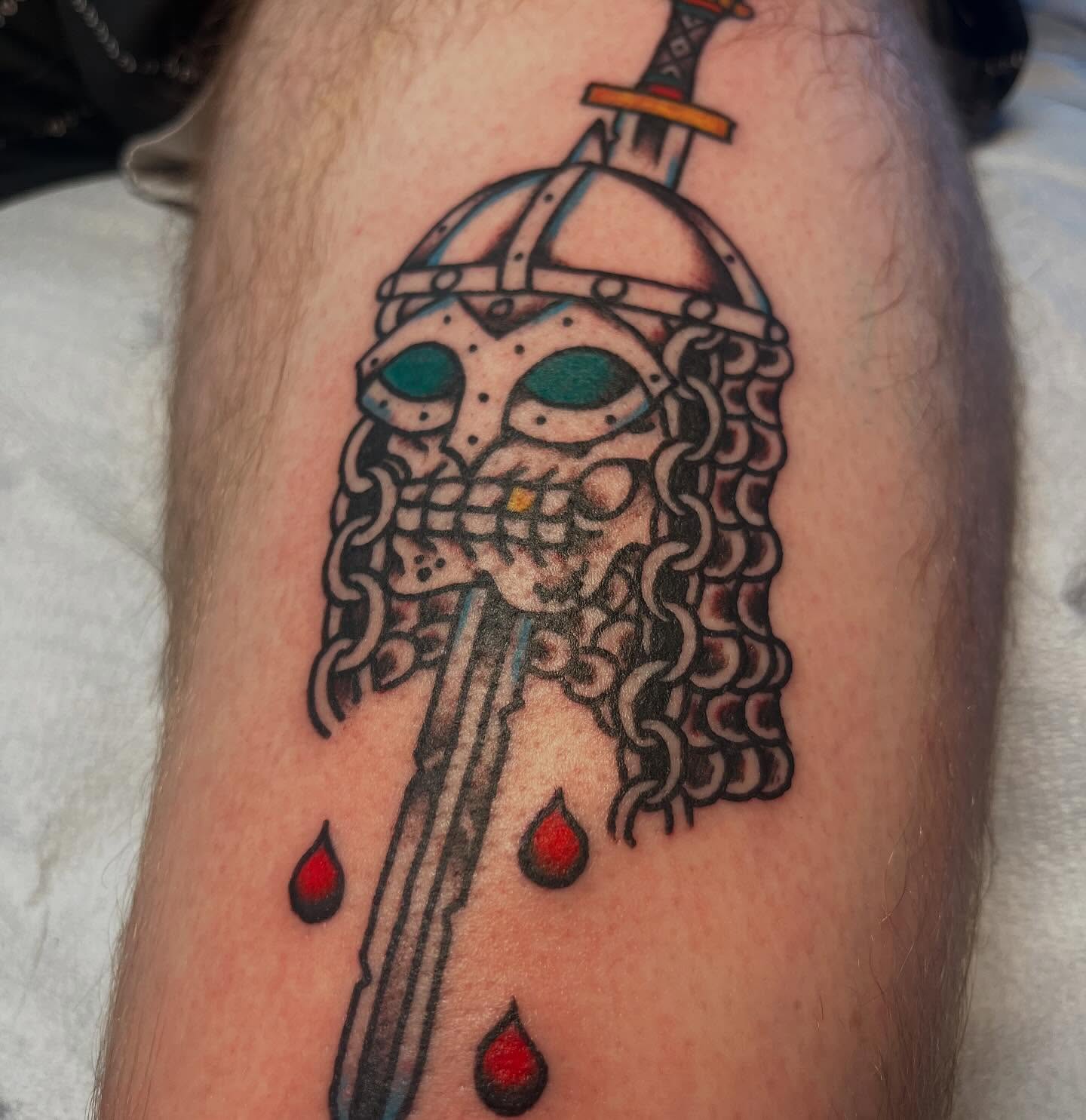 Viking helmet and sword American traditional tattoo on the forearm by monk