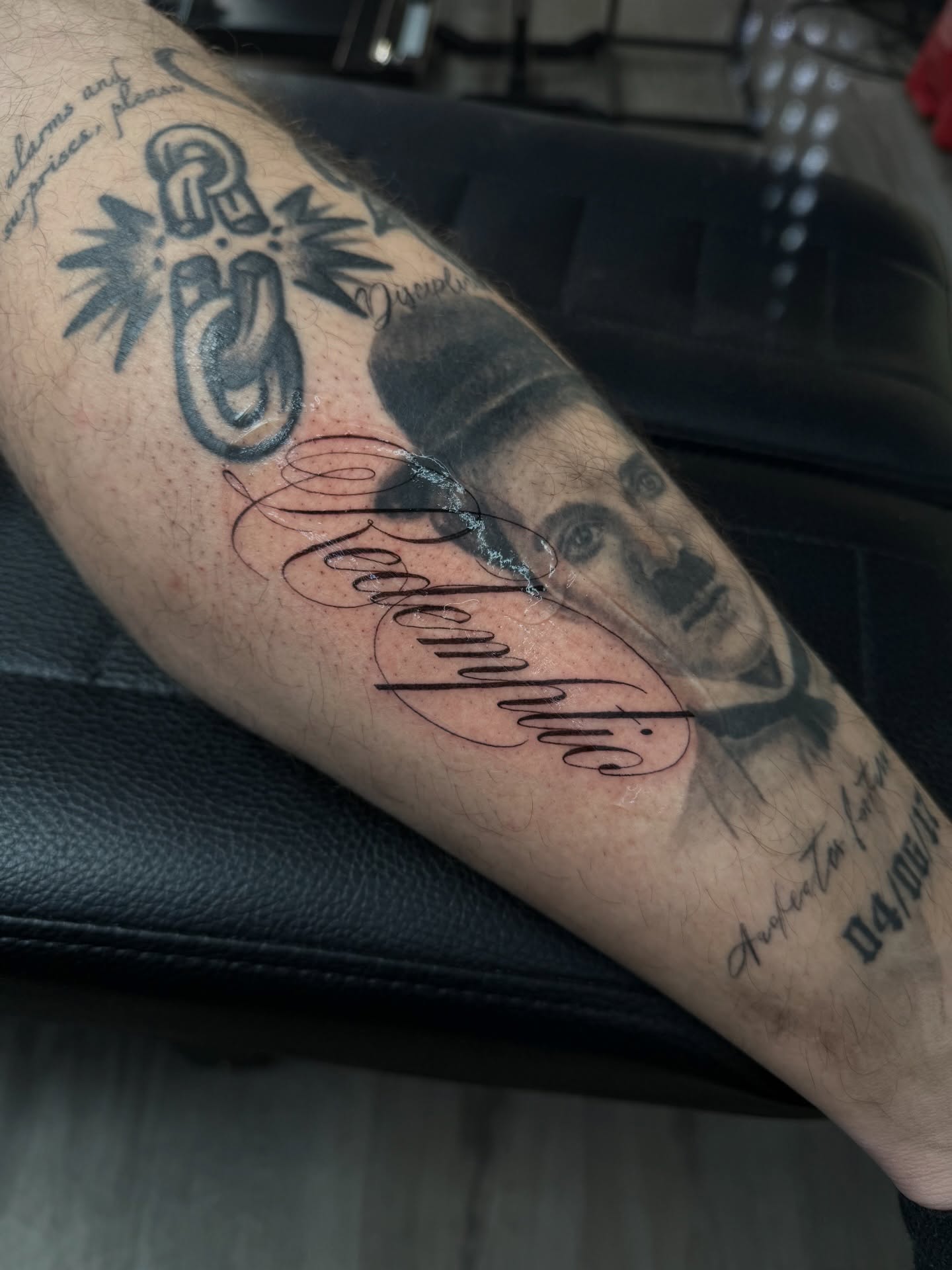 Portrait with text black and grey tattoo on the forearm by Elijah Cosme, Miami, Florida