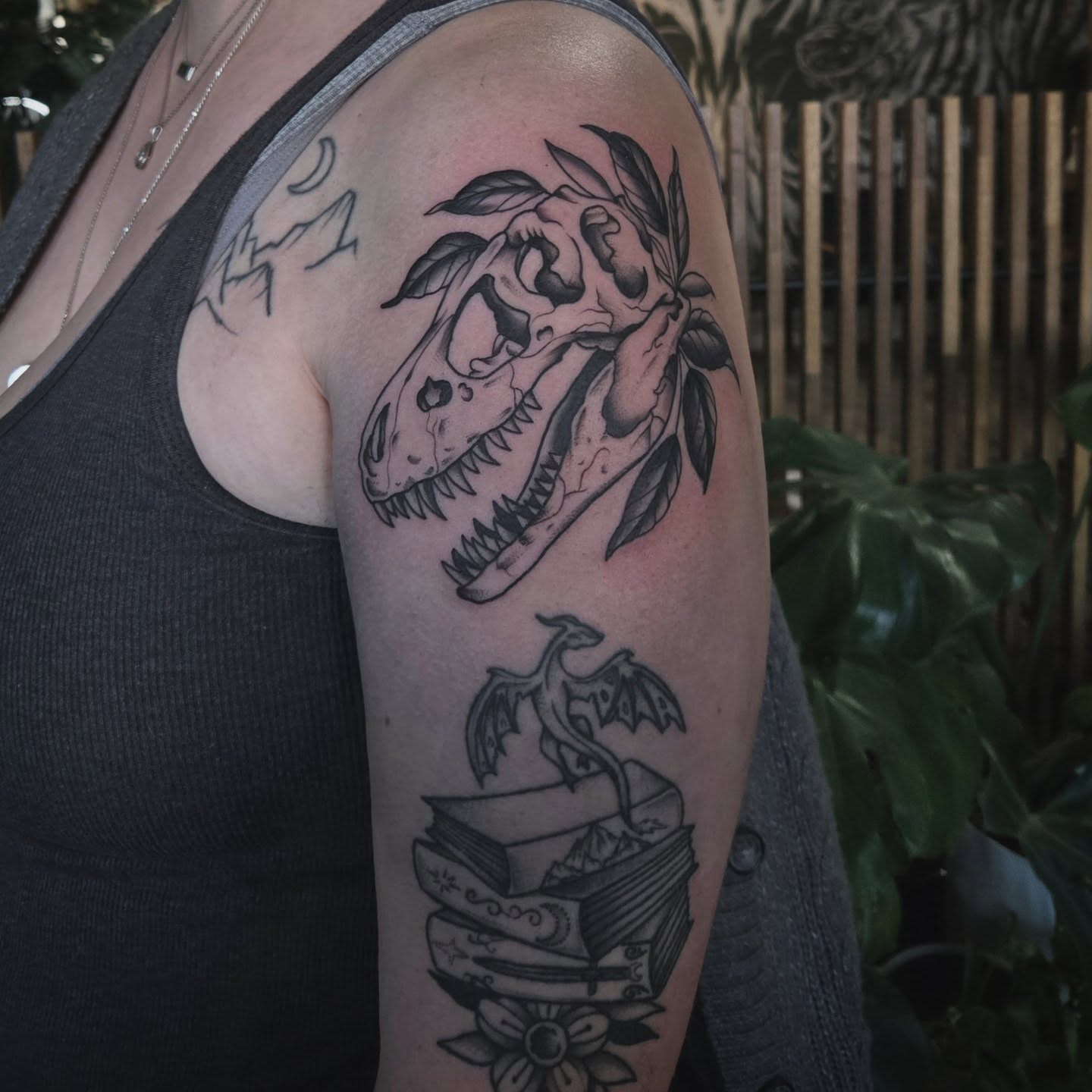 Dinosaur skull and dragon American traditional tattoo on the upper arm by Alexandra Colella ✨️