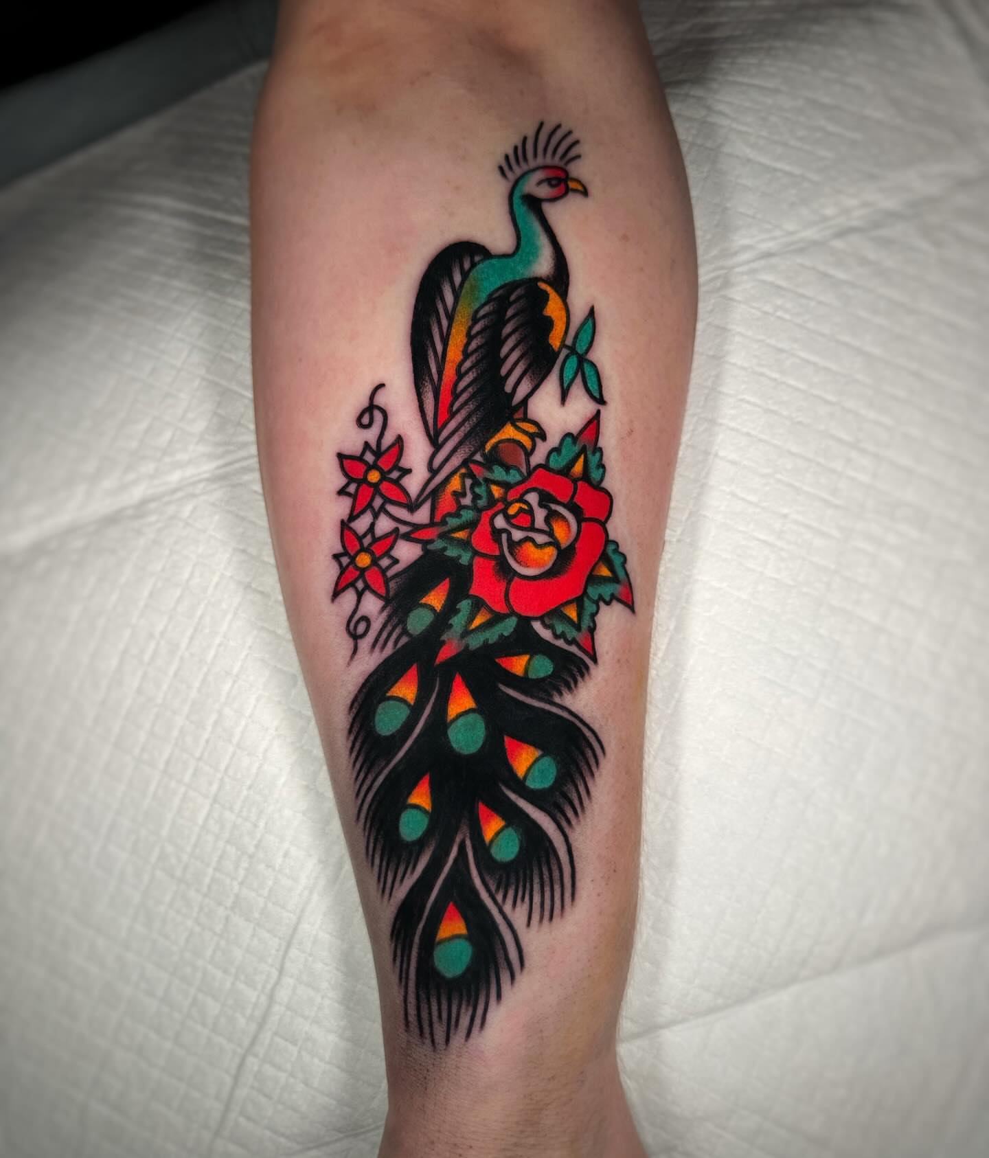 Peacock and floral American traditional tattoo on the forearm by Alex Finnerty, Reading, Massachusetts
