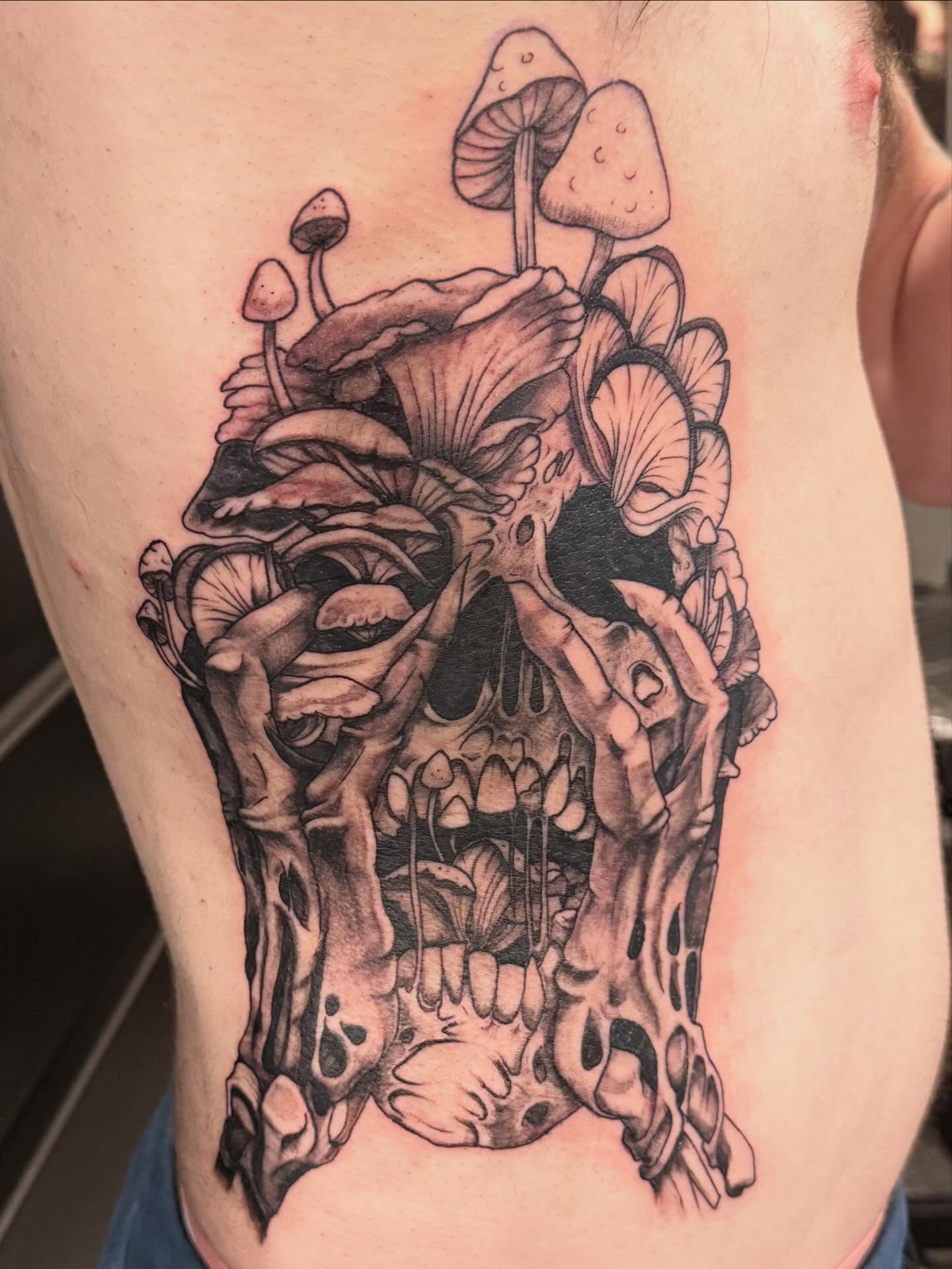 Skull and mushrooms realism tattoo on the ribs by Courtney