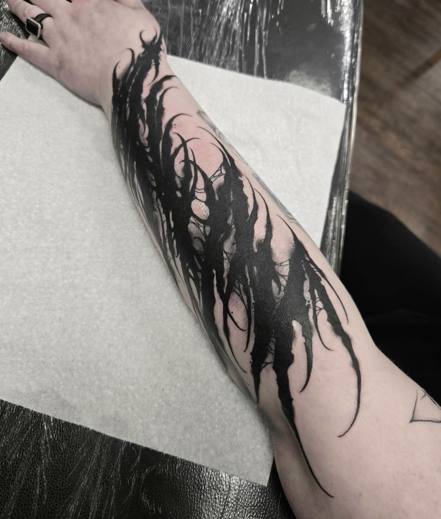 Abstract flame tribal tattoo on the forearm by ๐