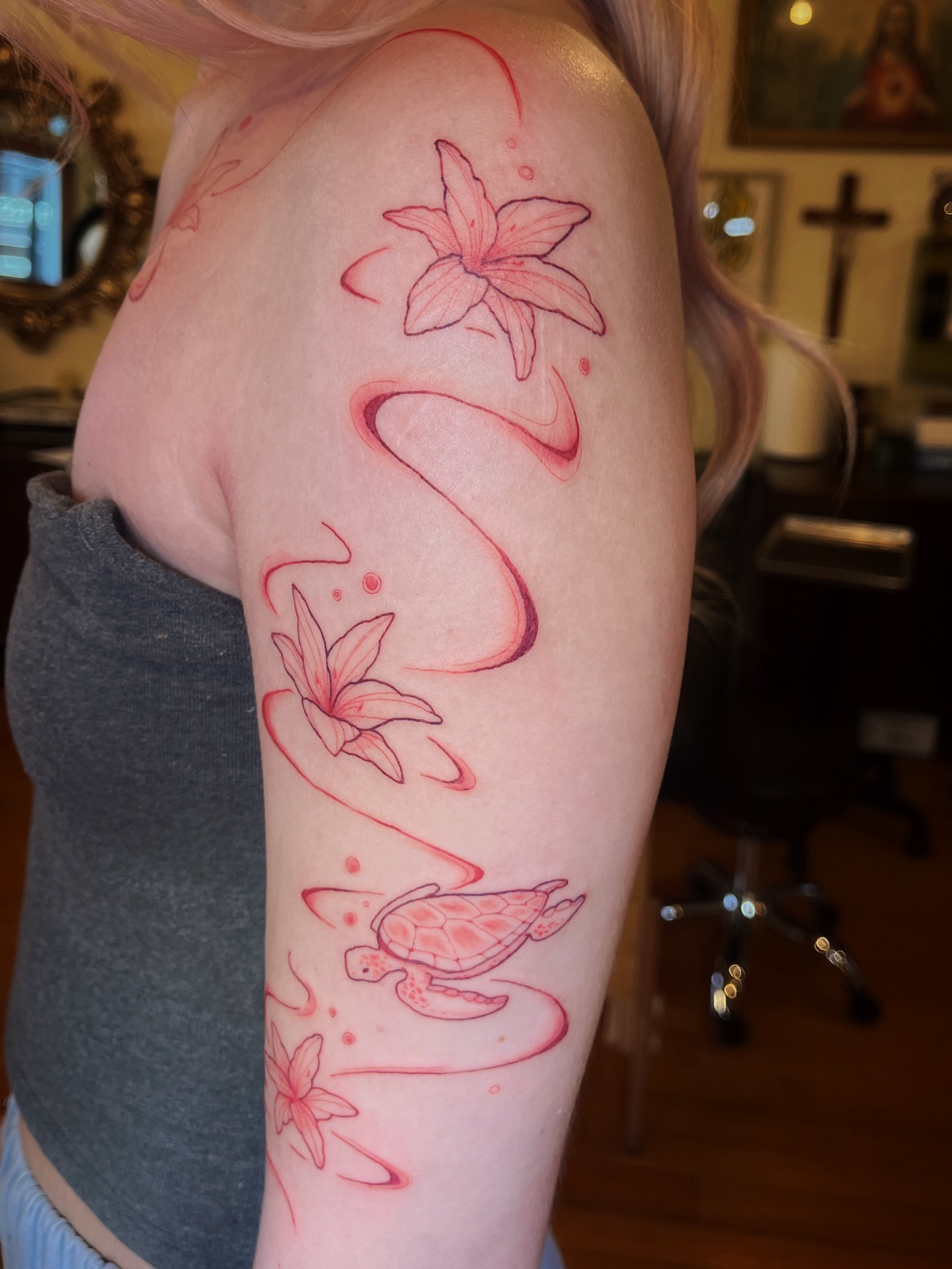 Lily and turtle fine line tattoo on the upper arm by Risa Cincinnati Tattoo Artist