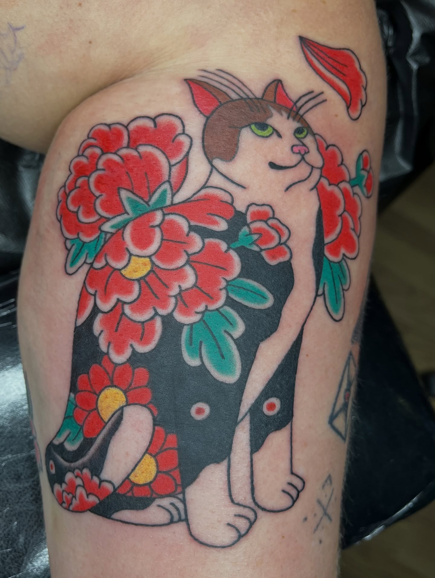 Cat and flowers American traditional tattoo on the thigh by Brian Easlon