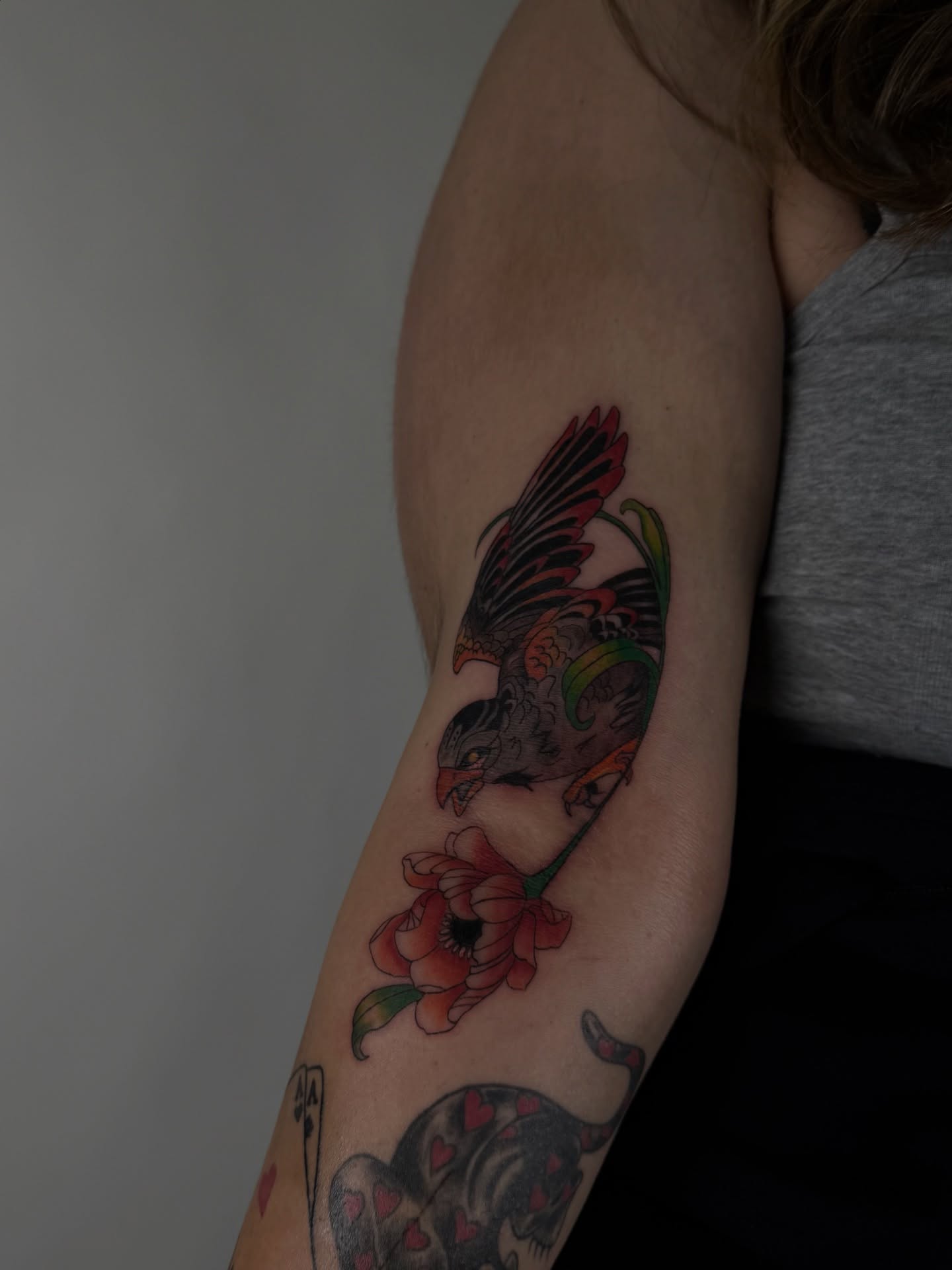 Bird and flowers American traditional tattoo on the forearm by sabina