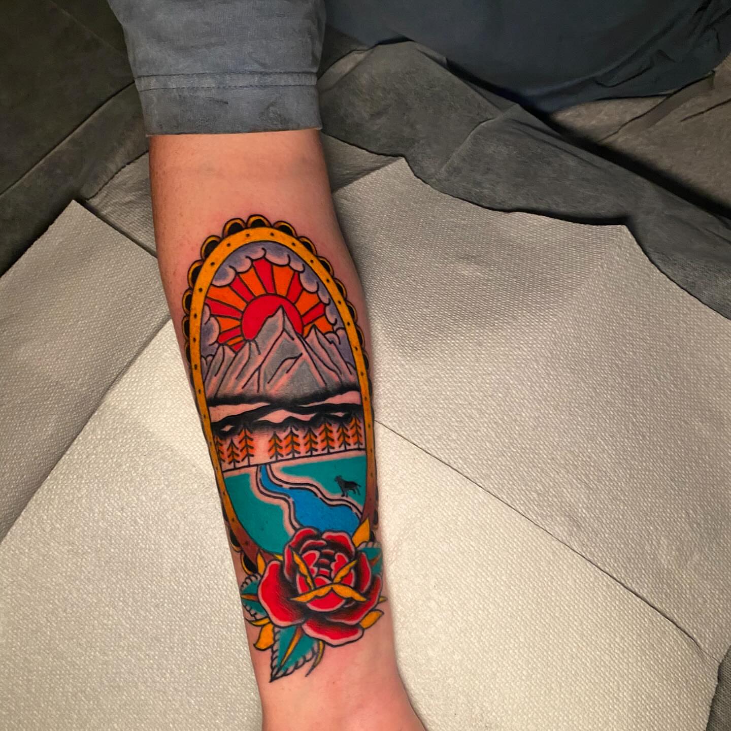 Mountain landscape with rose American traditional tattoo on the forearm by Nosferatu