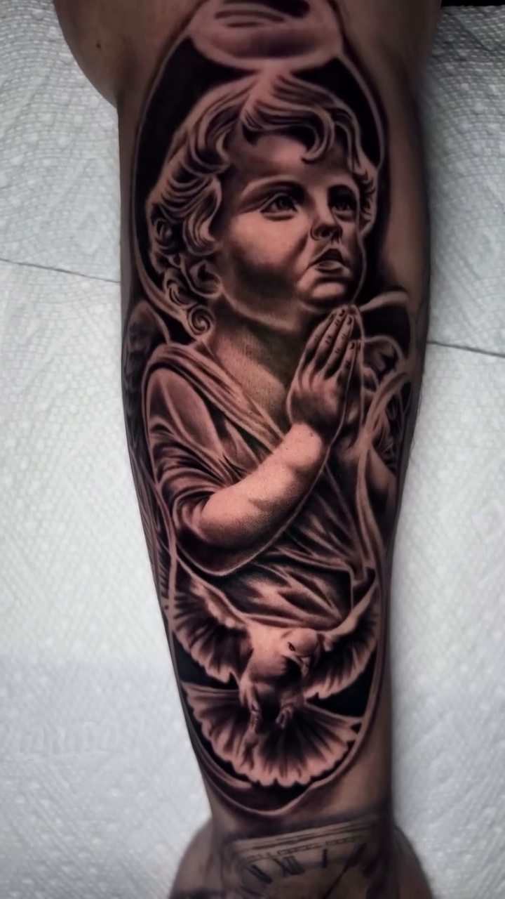 Cherub with praying hands and dove realism tattoo by Kevyn Vidal