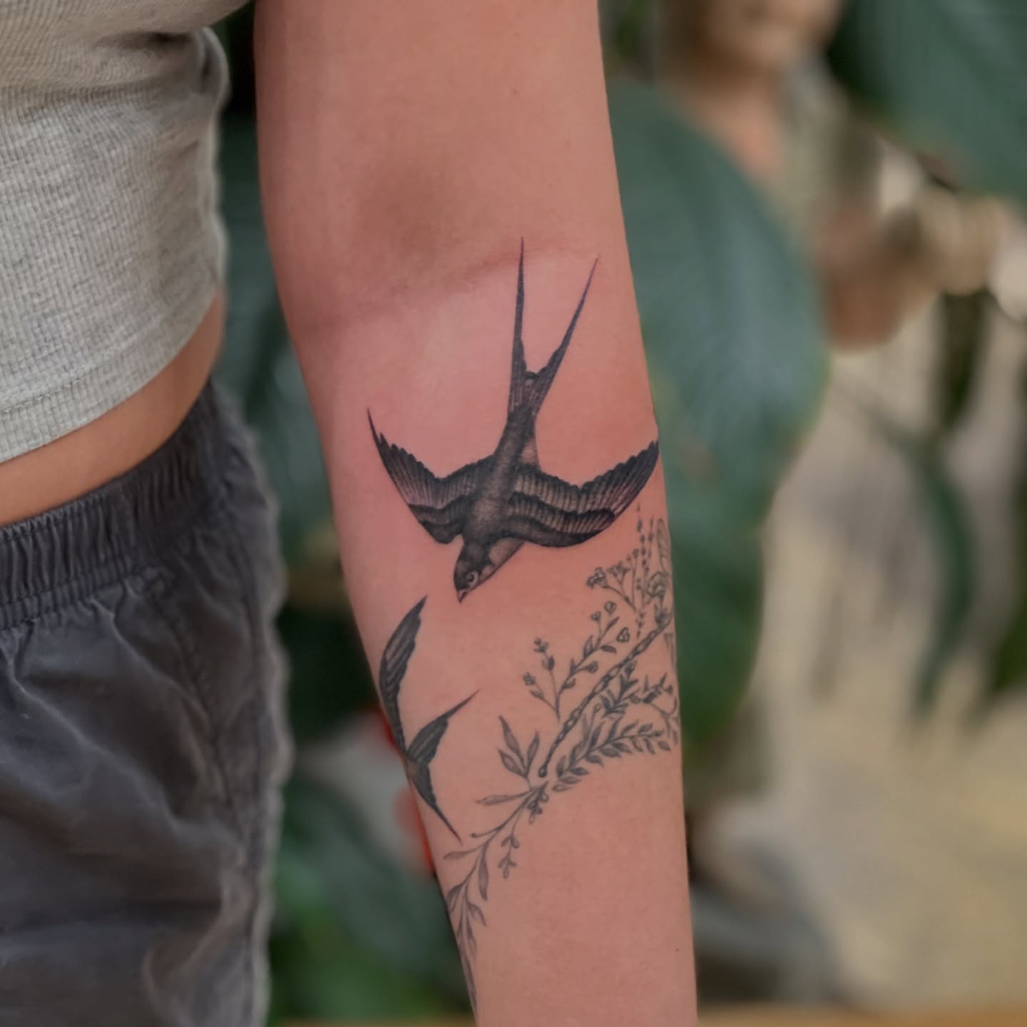 Swallow and floral realism tattoo on the forearm by James Fernella, San Francisco, California