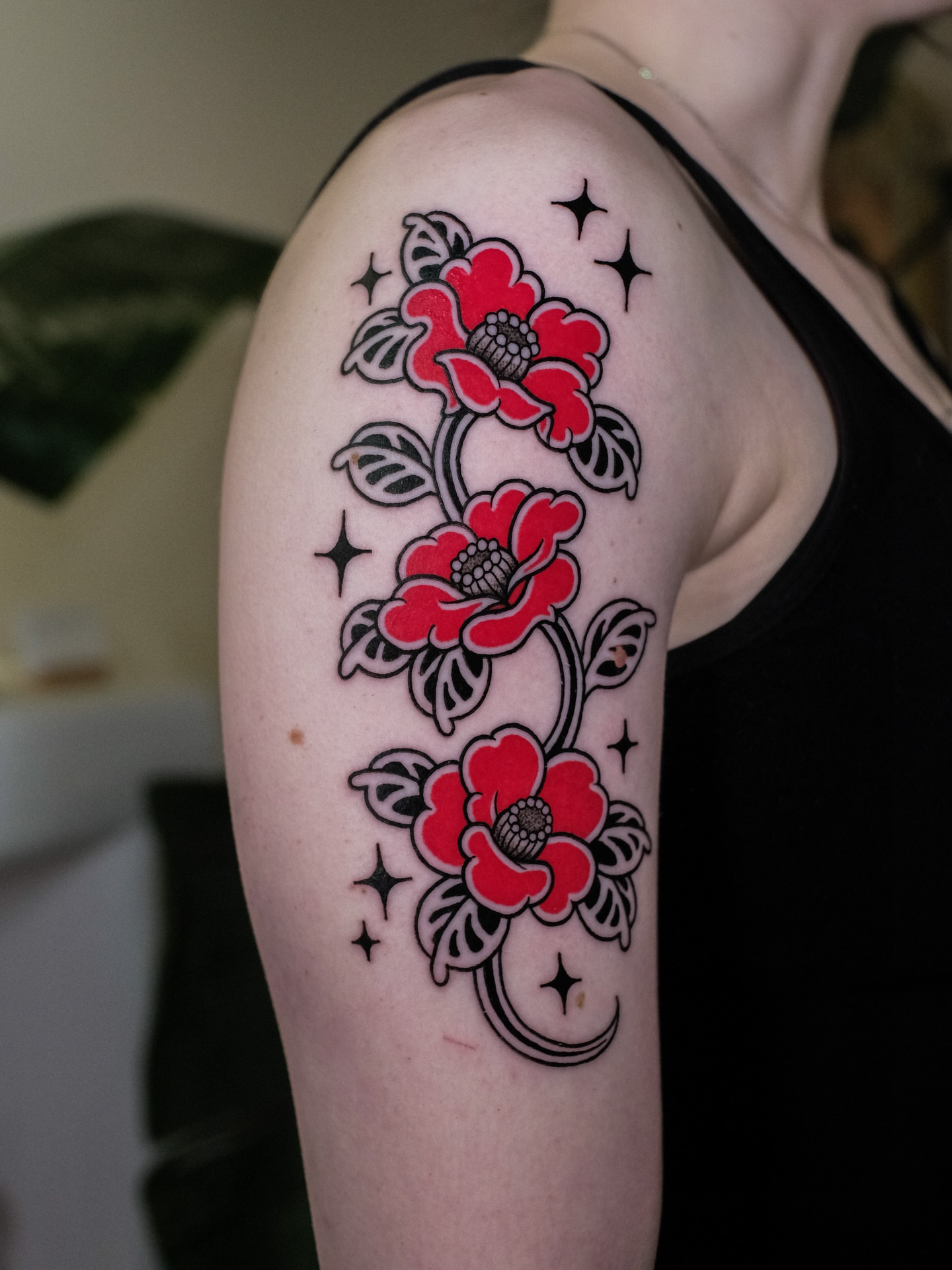 Flowers and stars American traditional tattoo on the upper arm by seattle tattoo artist