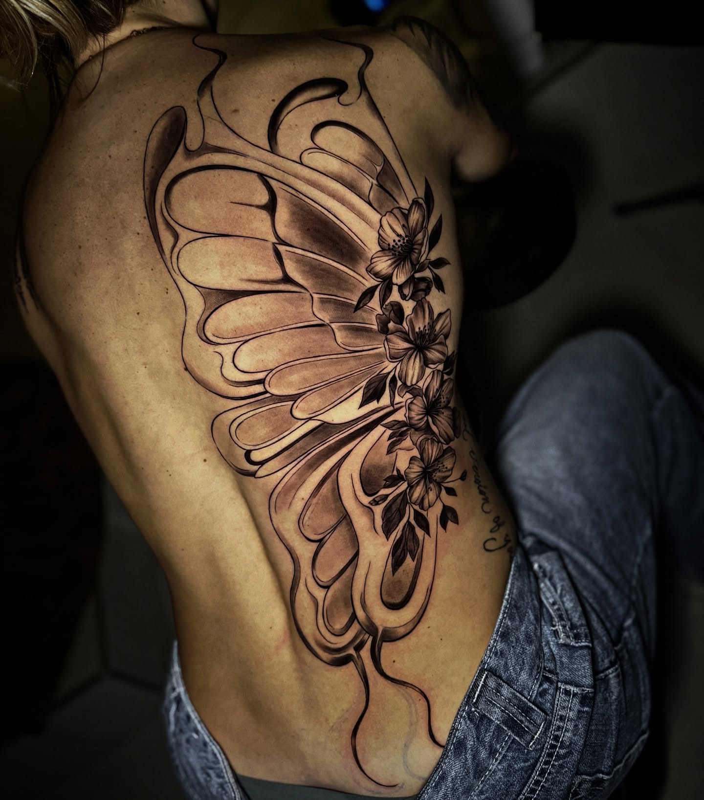 Wing and flowers ornamental tattoo on the back by Montreal Tattoo Artist
