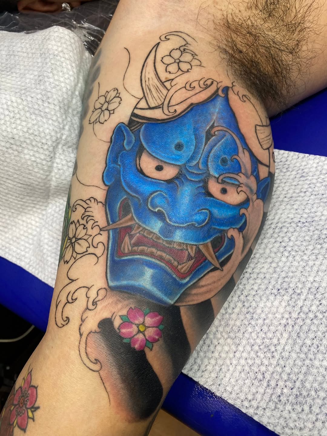 Blue oni mask with cherry blossoms Japanese tattoo on the forearm by Ferds Villanueva