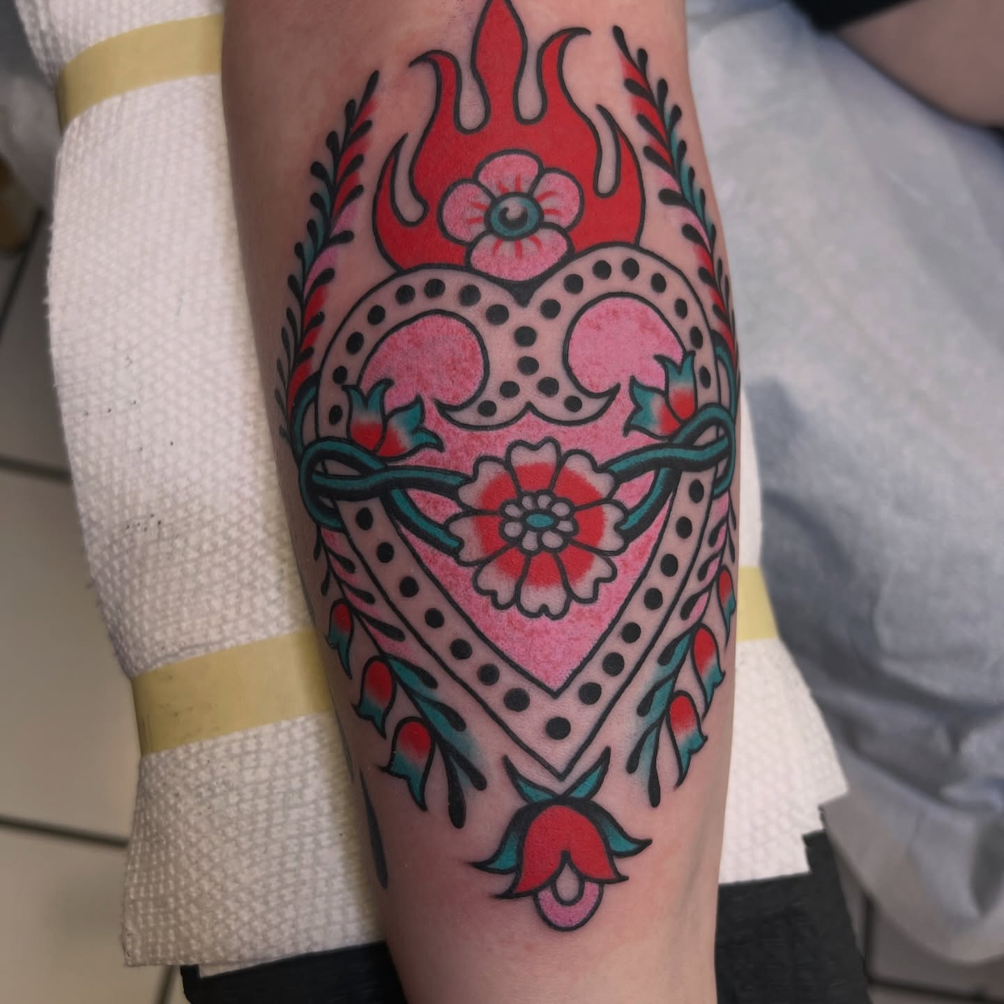 Flame and floral heart American traditional tattoo on the forearm by morganhabe