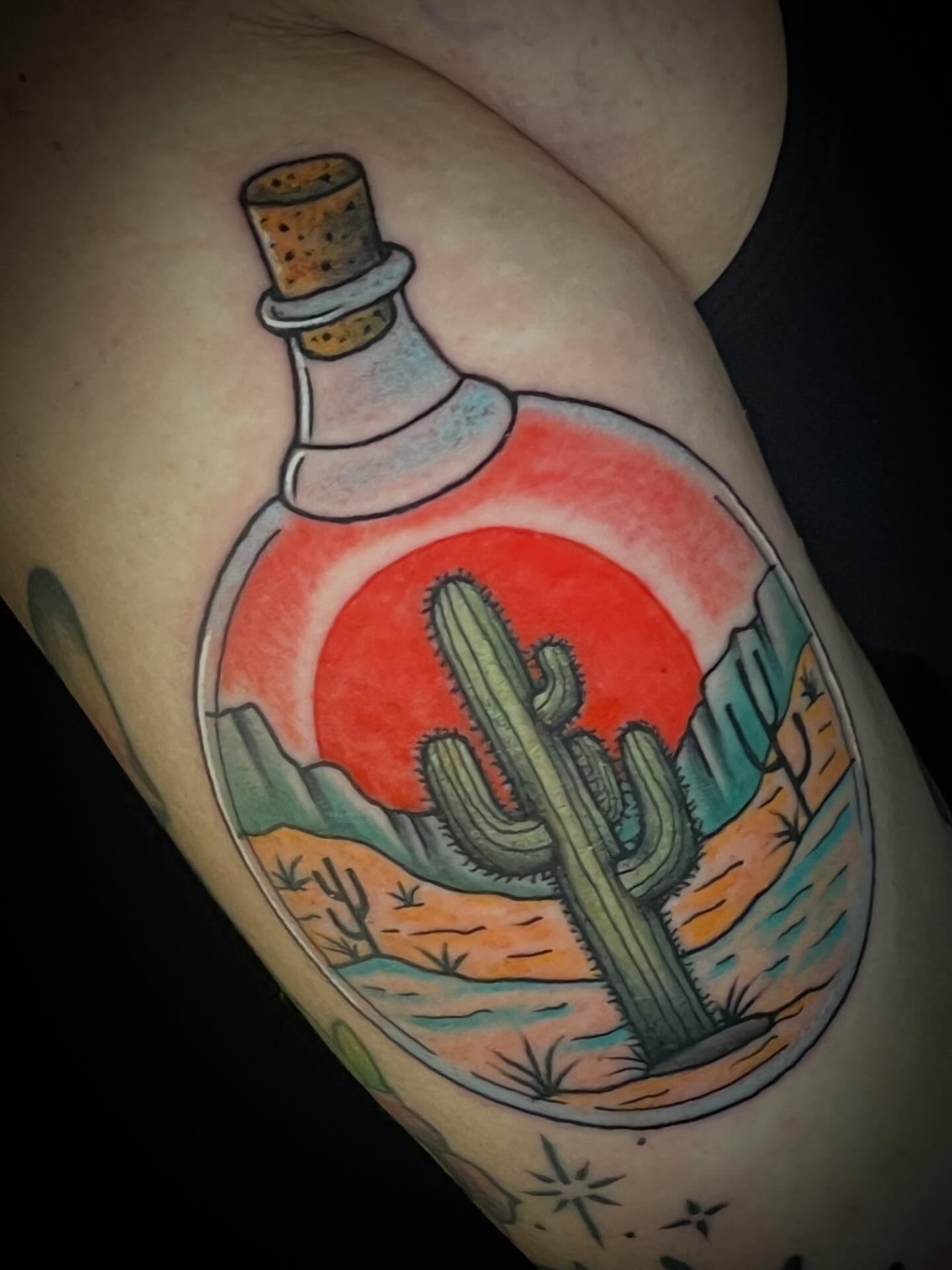 Desert landscape in bottle American traditional tattoo on the thigh by Suzanne B