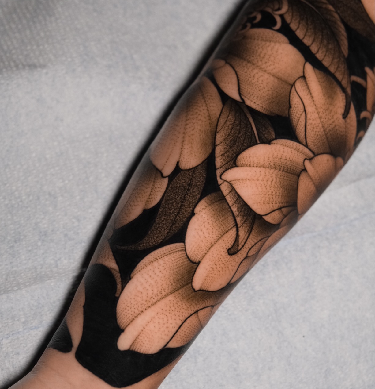 Floral pattern dotwork tattoo on the forearm by San Diego