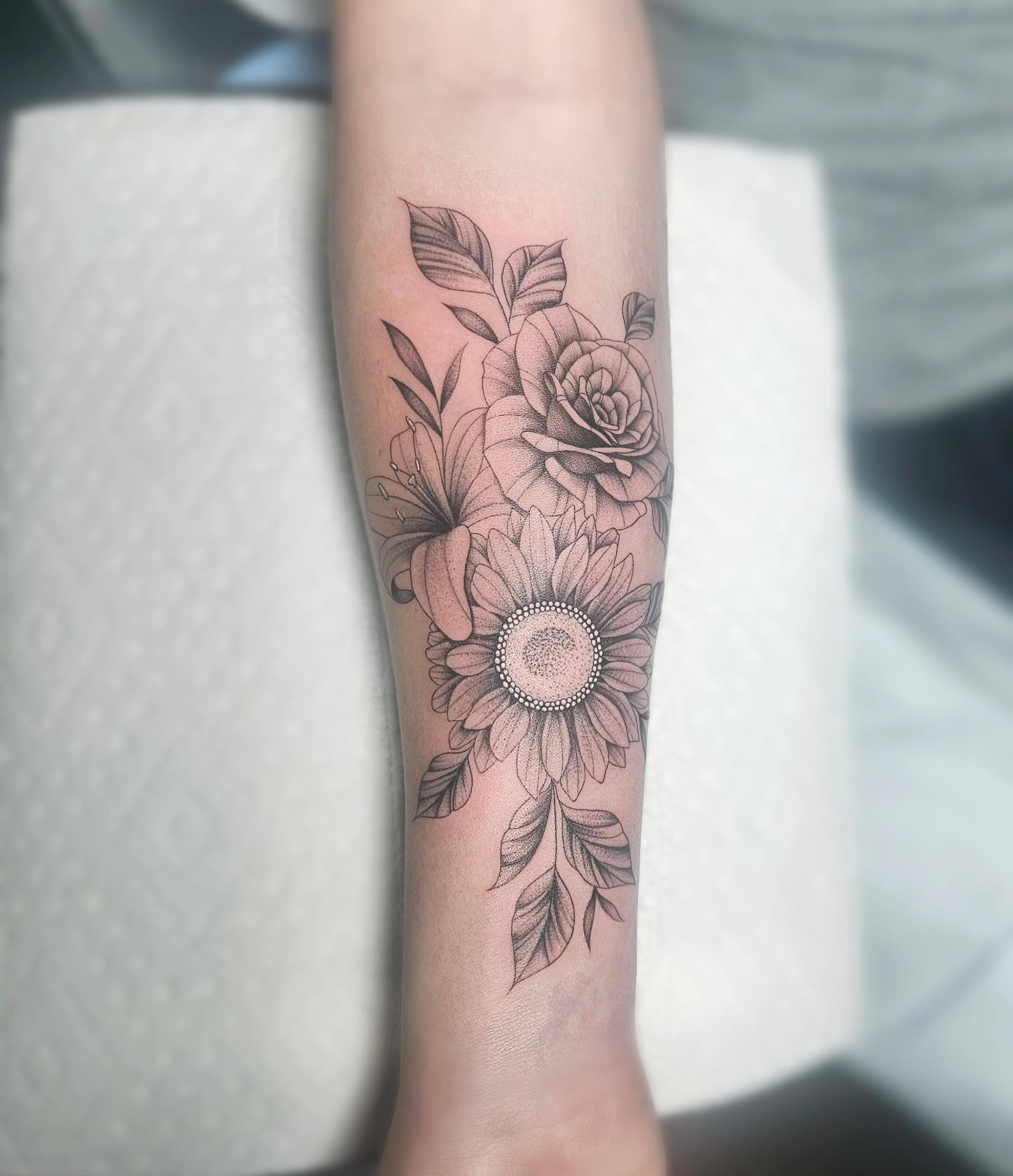 Sunflower and floral bouquet dotwork tattoo on the forearm by TaylorLeighShermanTattoos OFFICIAL