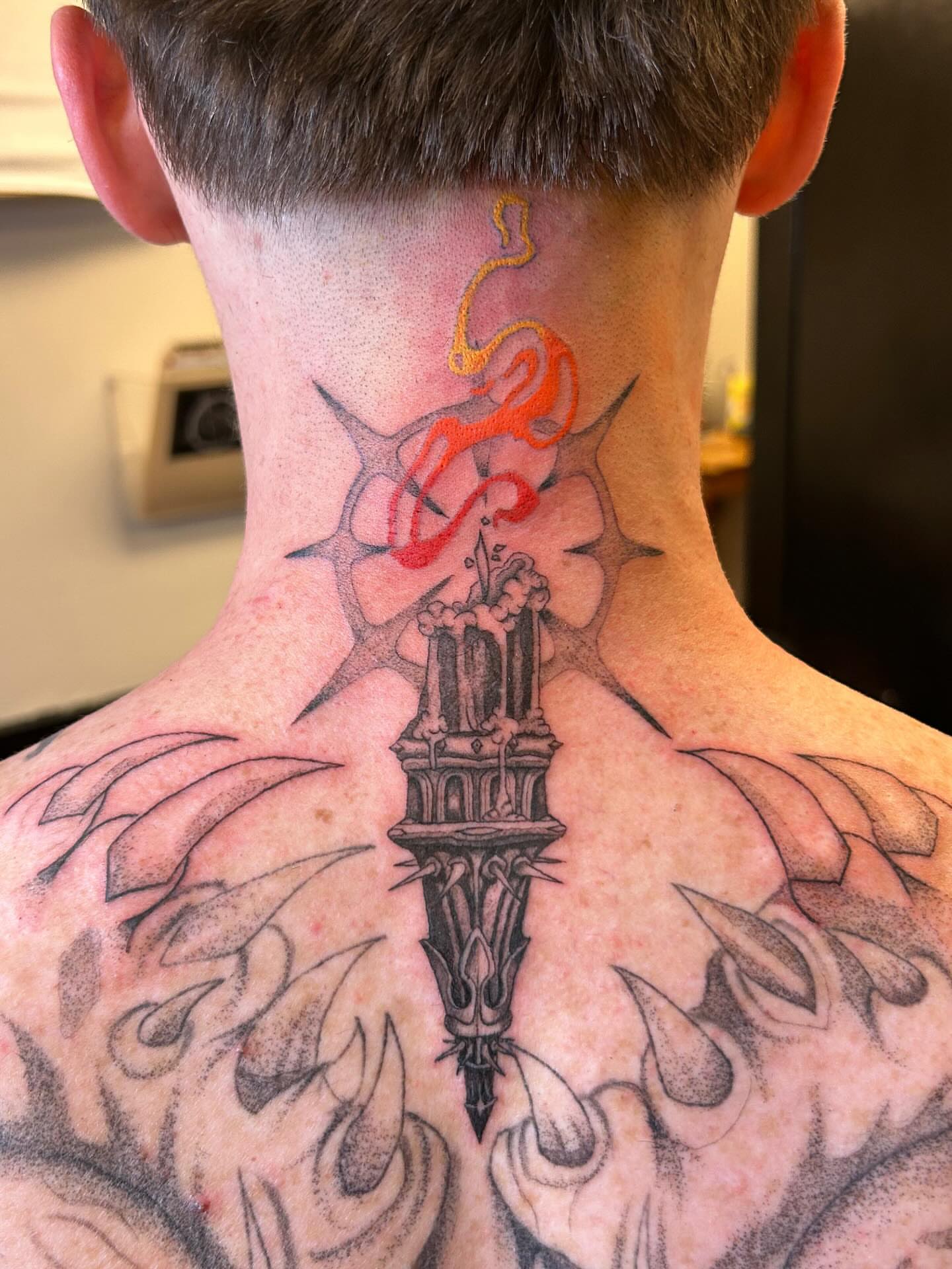 Tower with flames black and grey tattoo on the back by Chris