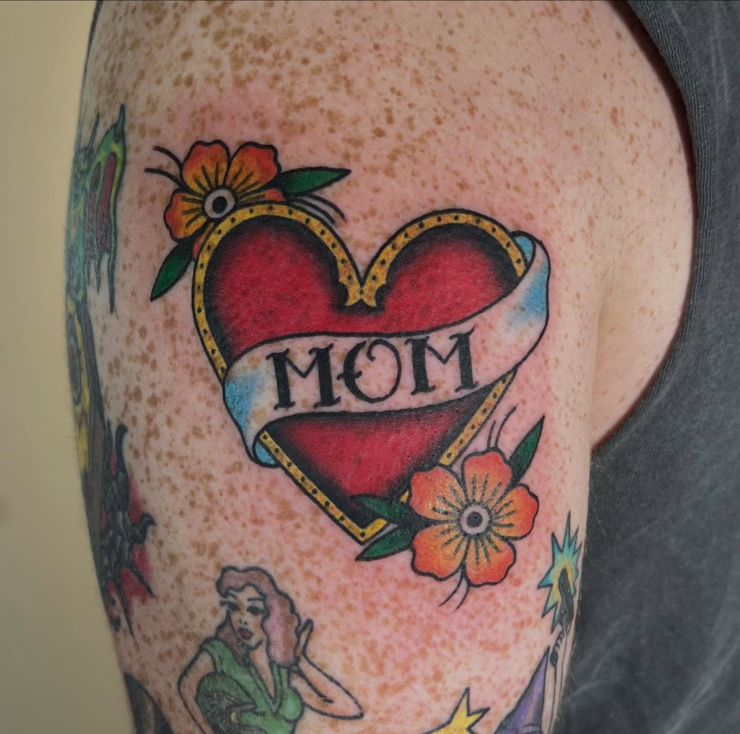 Heart with ribbon American traditional tattoo on the forearm by Juliet Miller