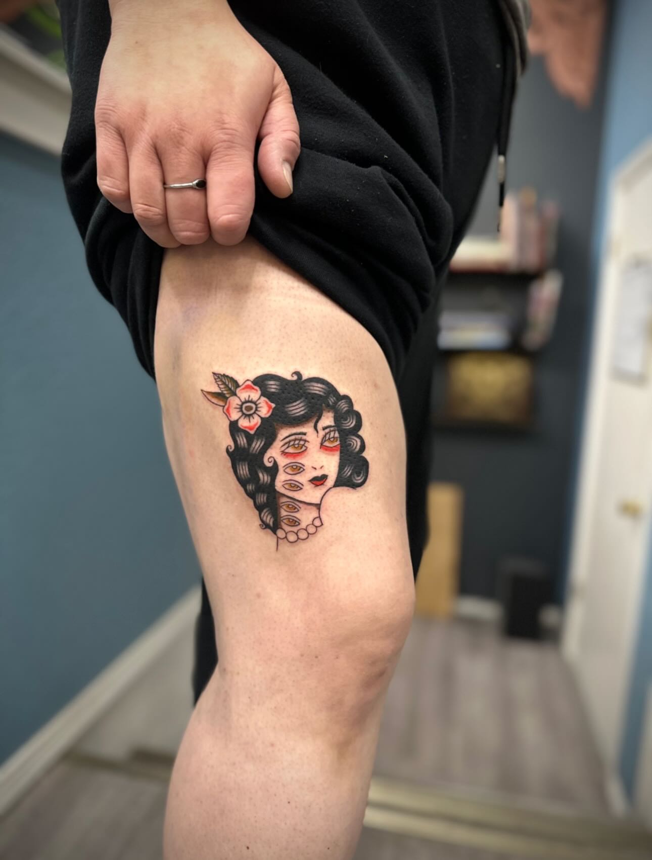 Woman with flower American traditional tattoo on the thigh by rory
