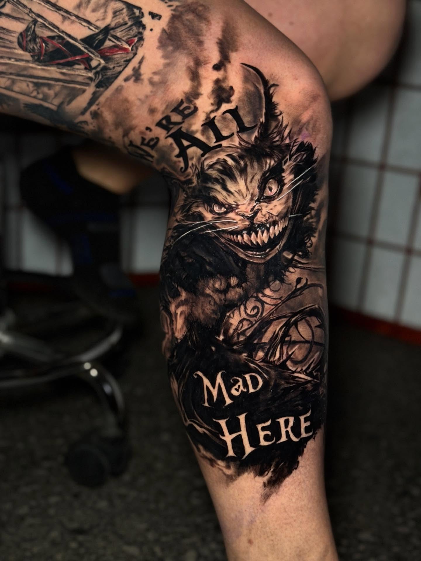 Cheshire cat dark realism tattoo on the forearm by Johnny Scillieri