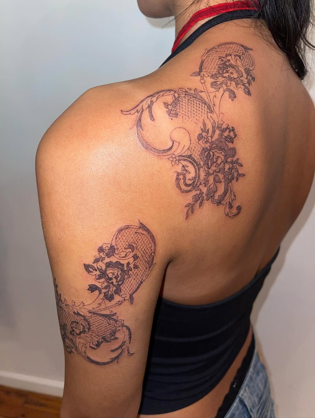 Lace and floral design ornamental tattoo on the back by @initiationoftorture