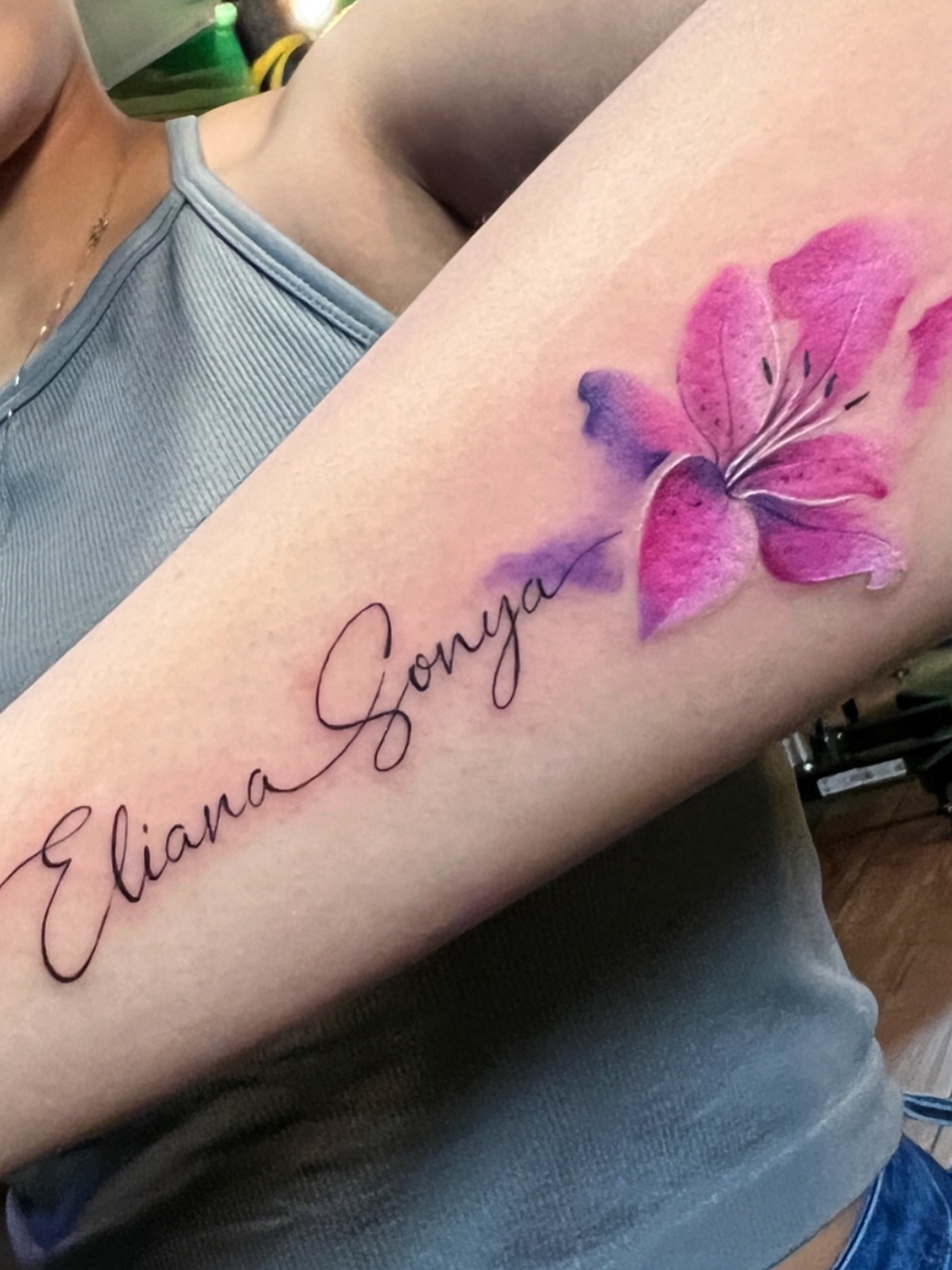 Lily and name watercolor tattoo on the forearm by BRIK RANGEL - Tattoo Artist
