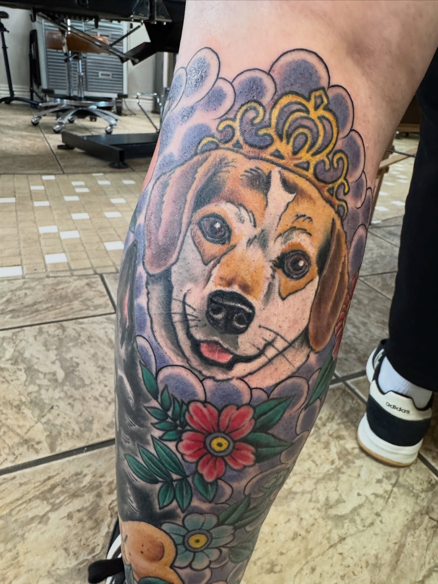 Dog wearing crown American traditional tattoo on the leg by Cary Aldridge