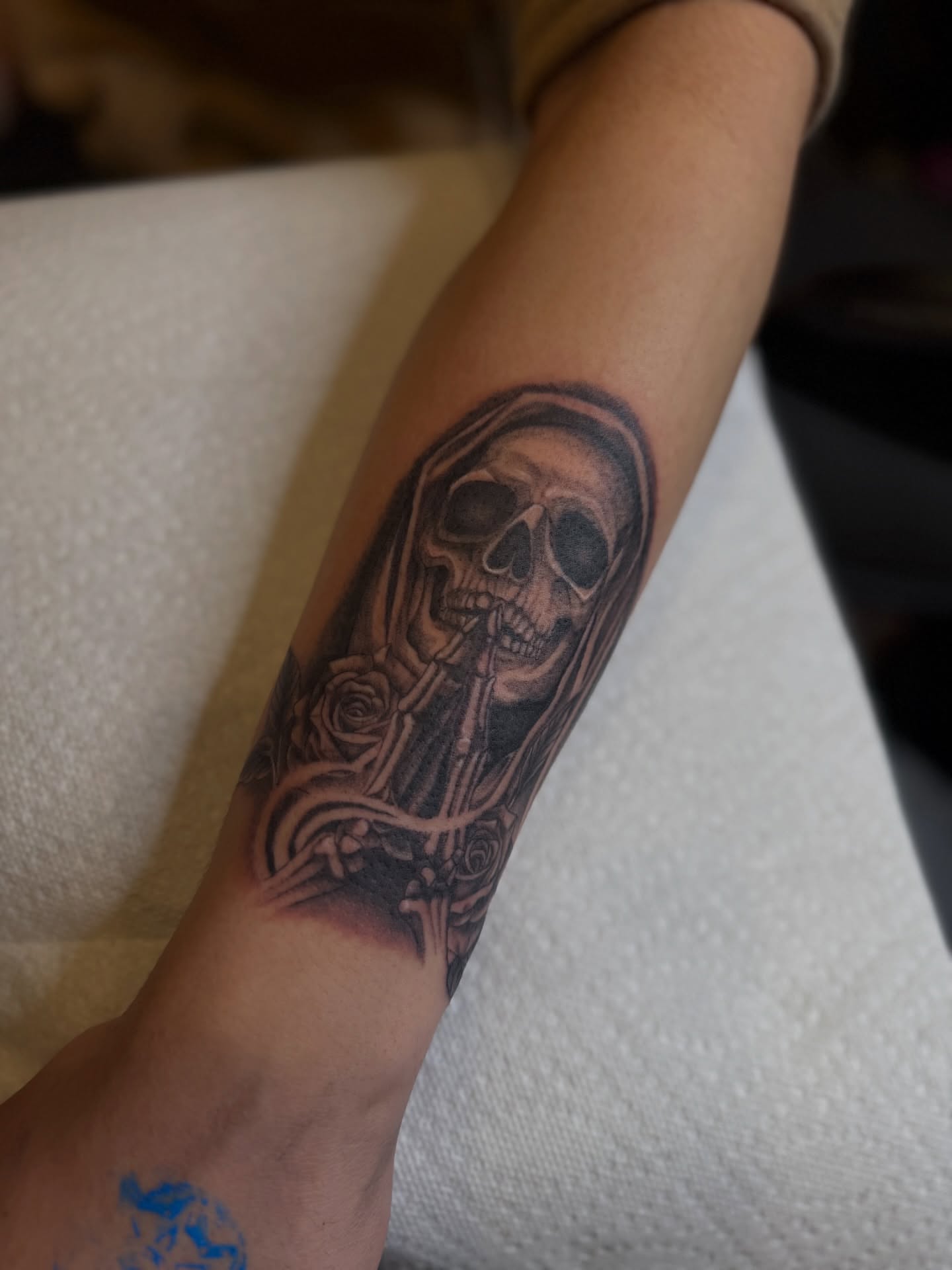 Skull with roses realism tattoo on the forearm by Los Angeles Tattoo Artist