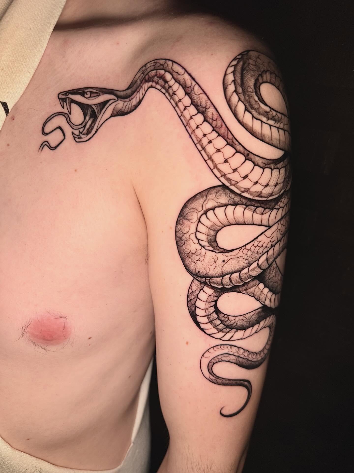 Snake black and grey tattoo on the shoulder by Kayla Rosencrans