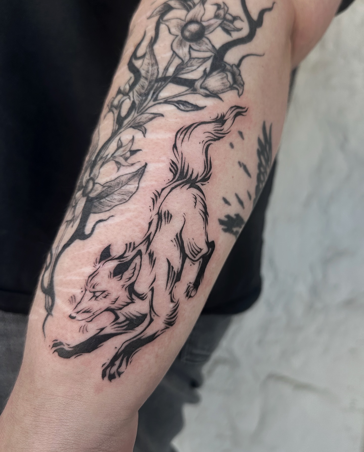Fox and flowers black and grey tattoo on the forearm by Micky, Austin, Texas
