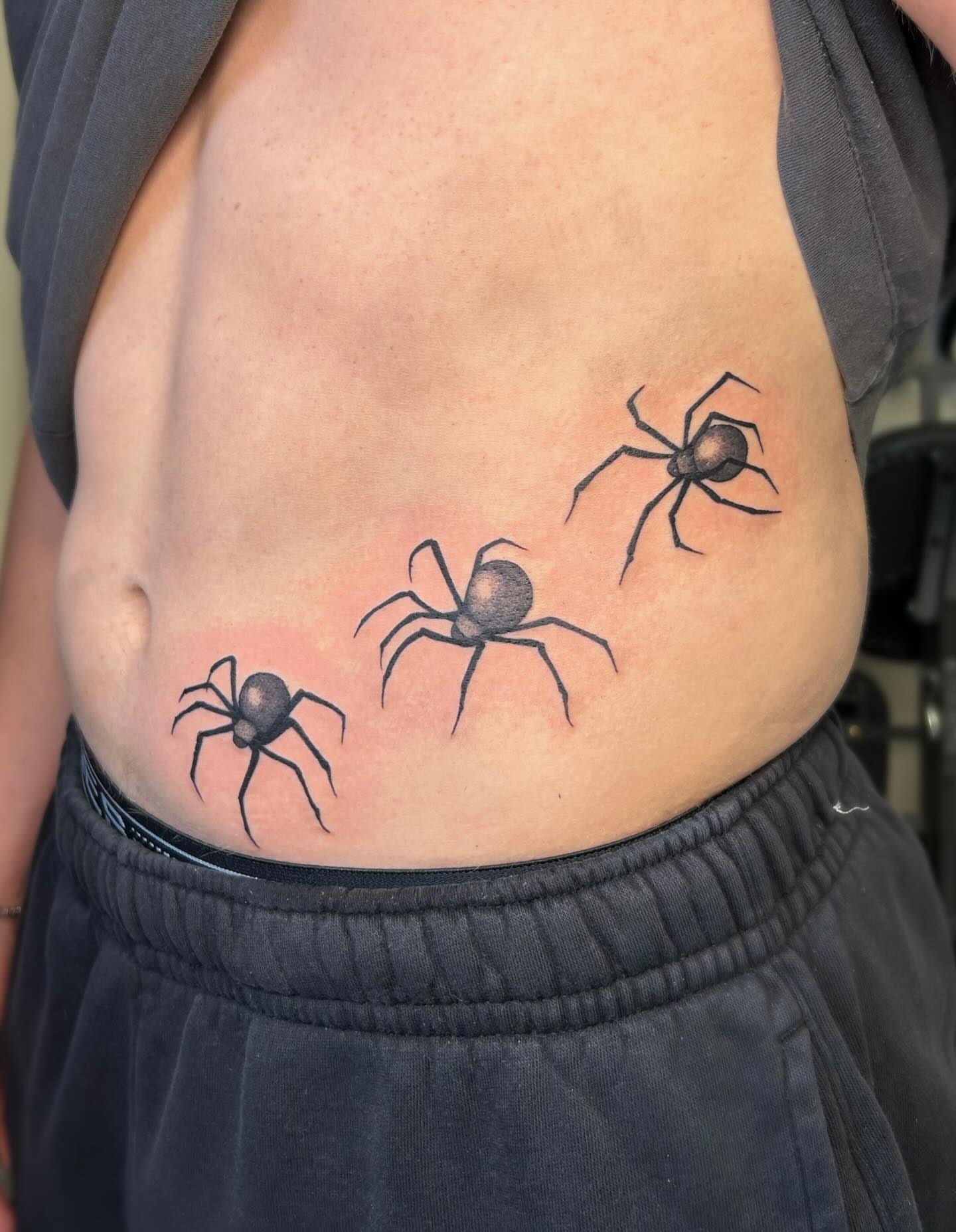 Spiders black and grey tattoo on the ribs by kuna ink