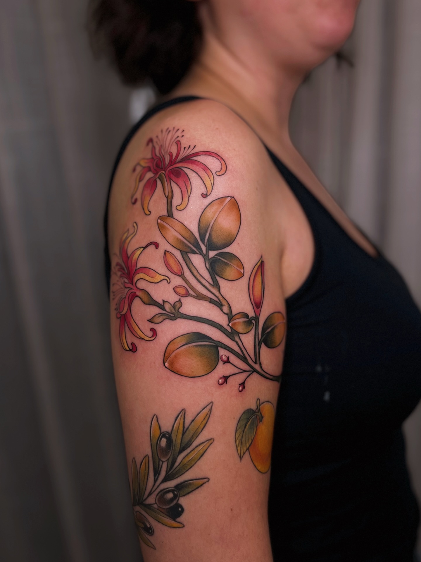 Floral arrangement realism tattoo on the upper arm by Kyla Jae
