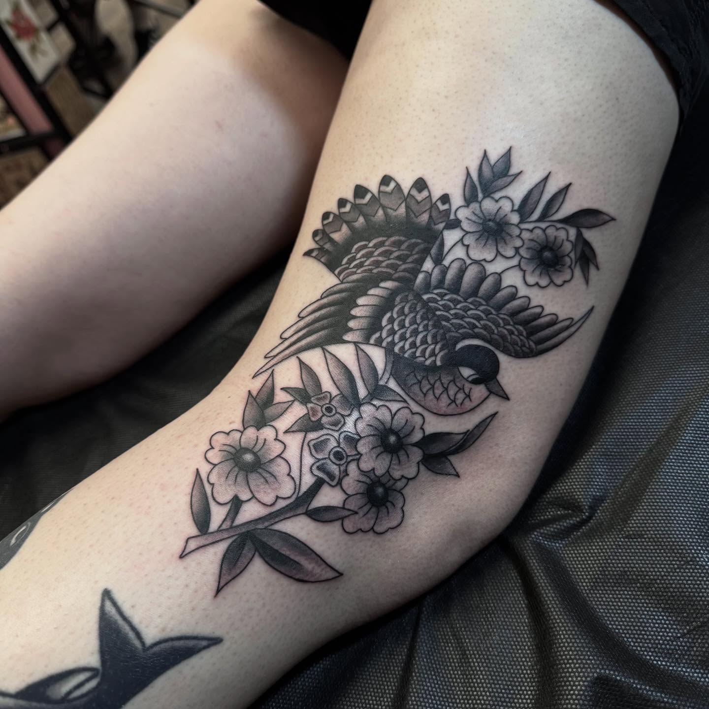 Bird and flowers black and grey tattoo on the forearm by Landon Lewis