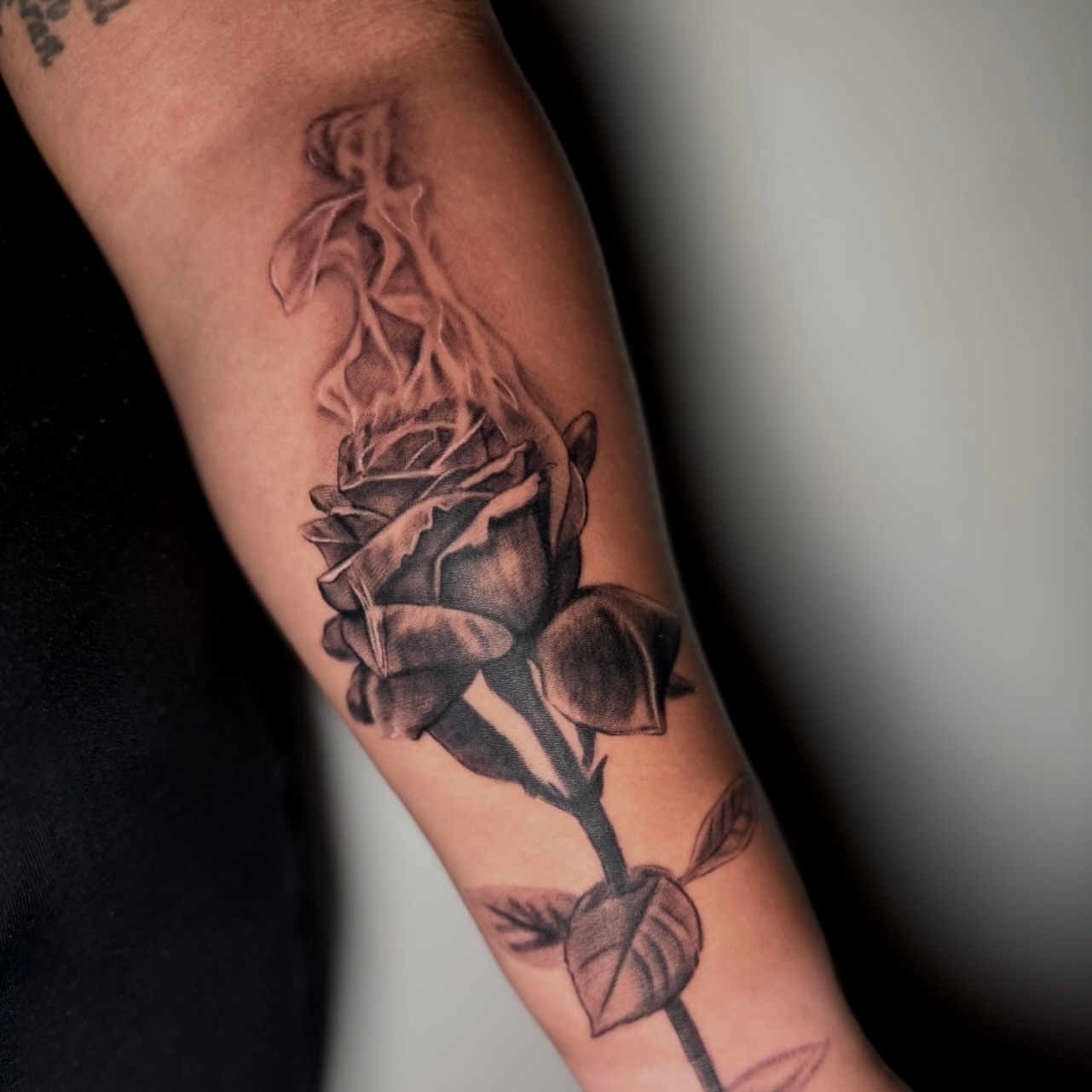 Burning rose realism tattoo on the forearm by Montreal Tattoo Artist
