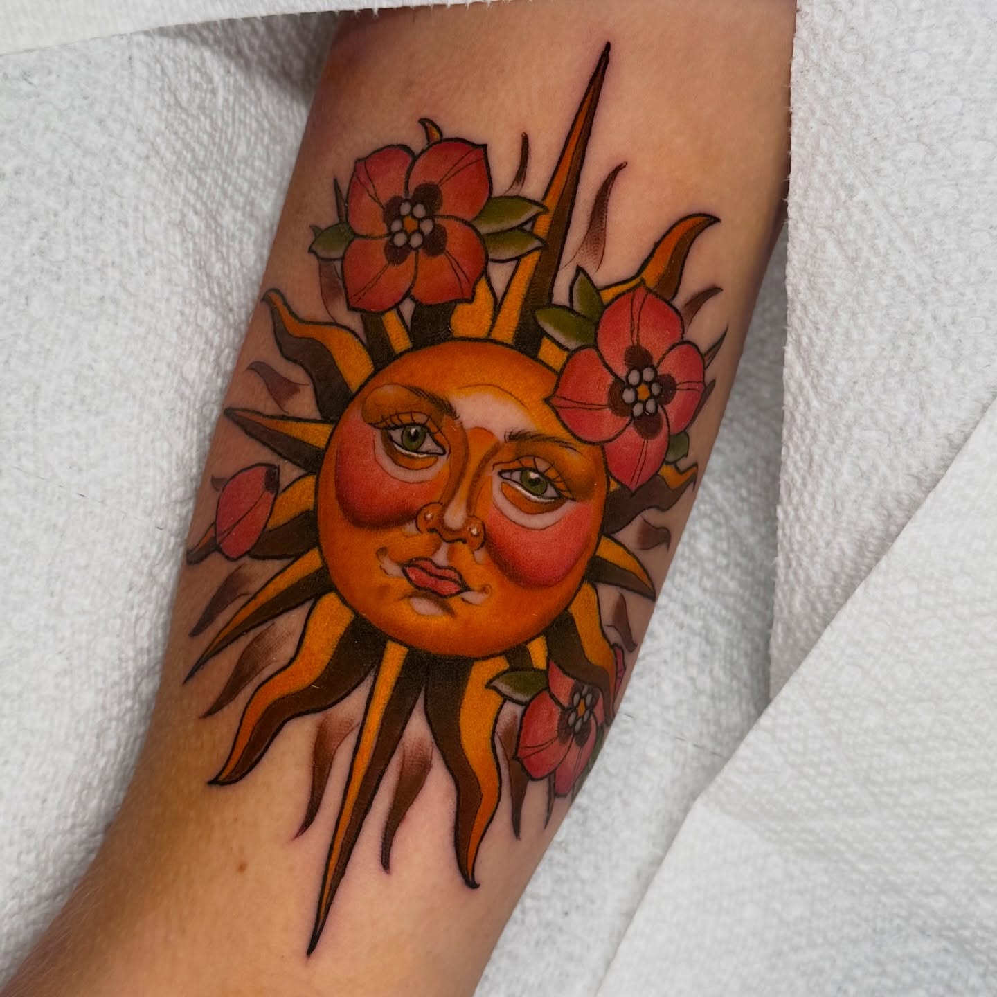 Sun and flowers illustrative tattoo on the forearm by Kyle Kuhn