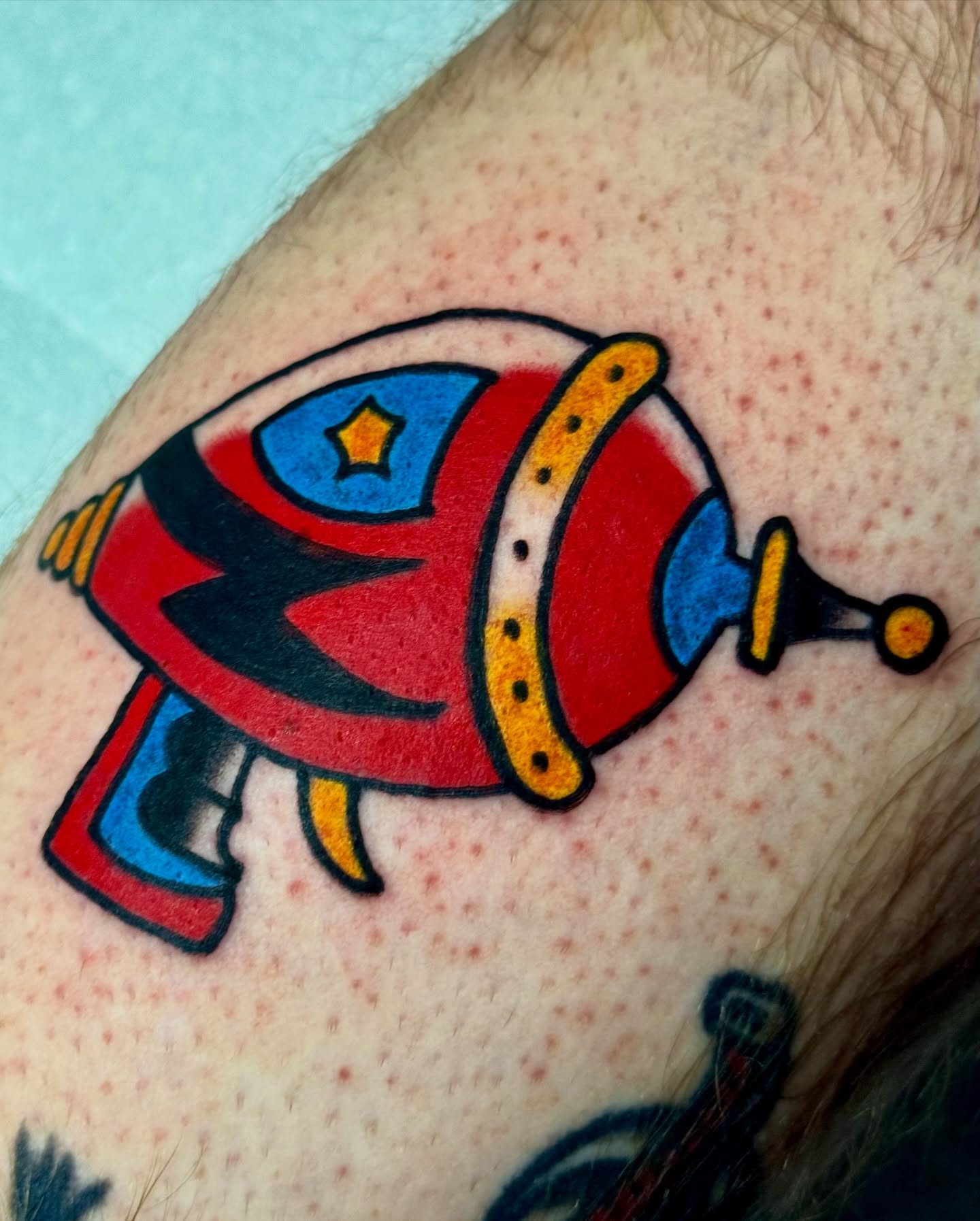 Spaceship American traditional tattoo on the upper arm by Javin Klingelhoefer Mosley