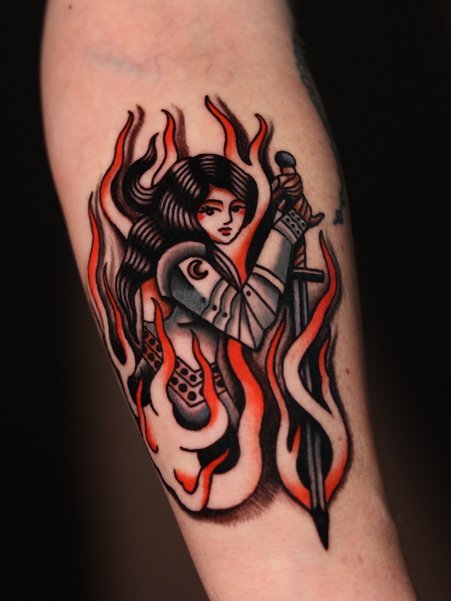 Flame-wrapped warrior American traditional tattoo on the forearm by Dylan Mott