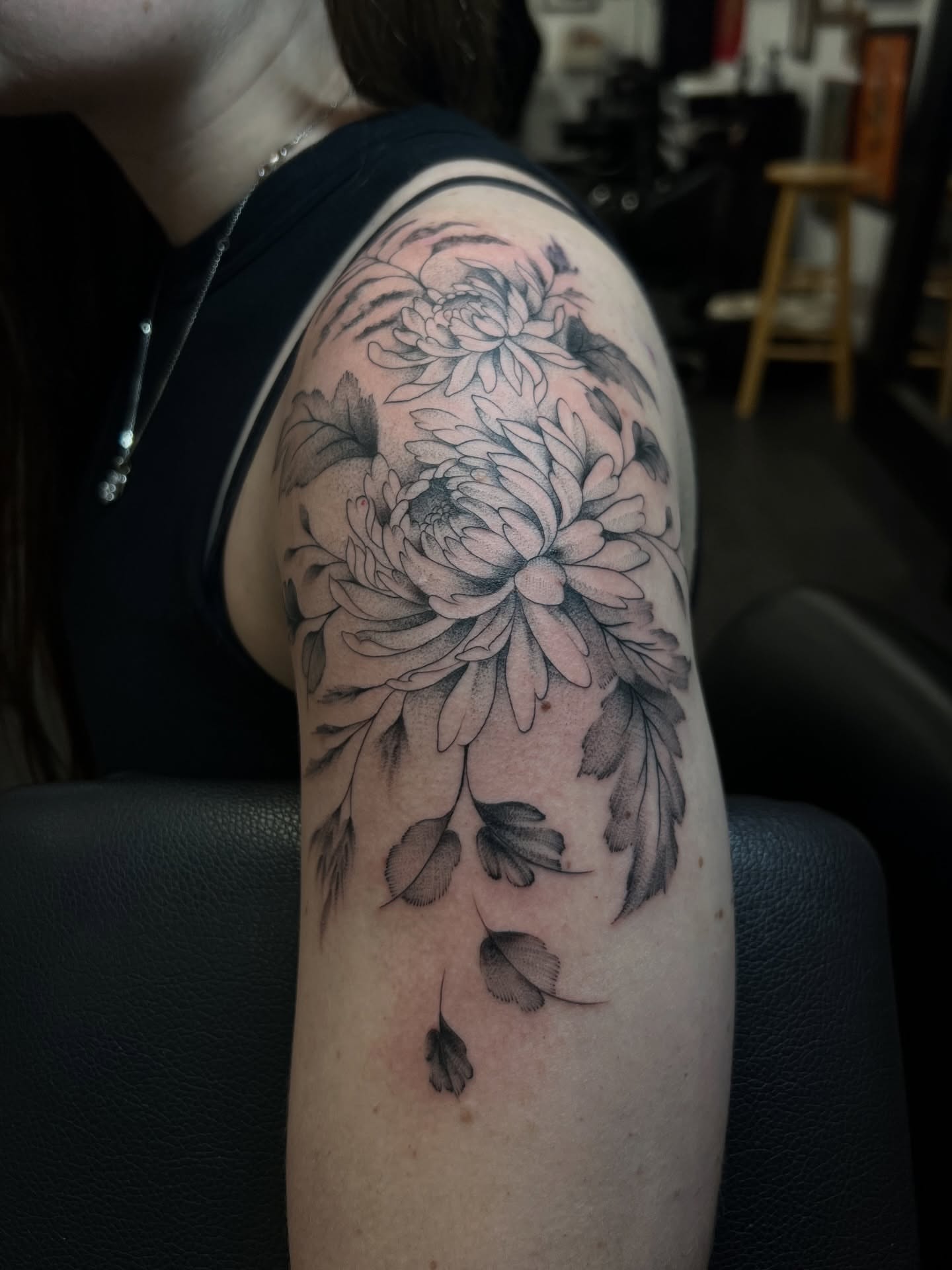 Chrysanthemum black and grey tattoo on the upper arm by Chloe
