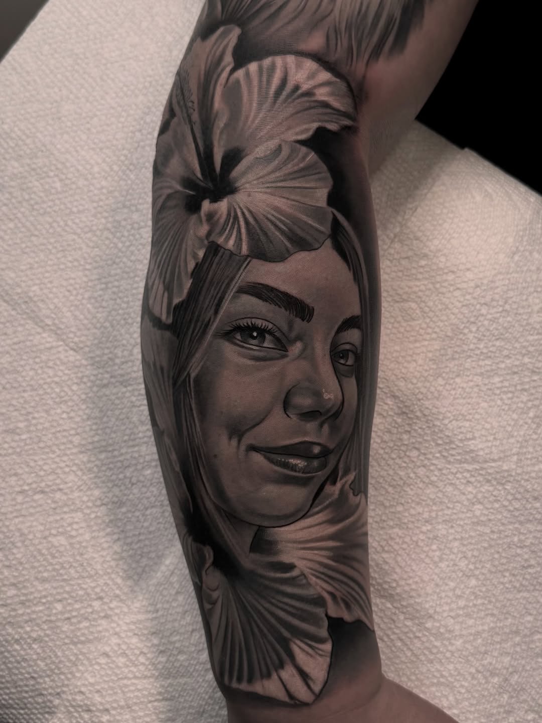 Portrait of a woman with flowers realism tattoo on the forearm by Luis Manuel Olivera, North Miami, Florida