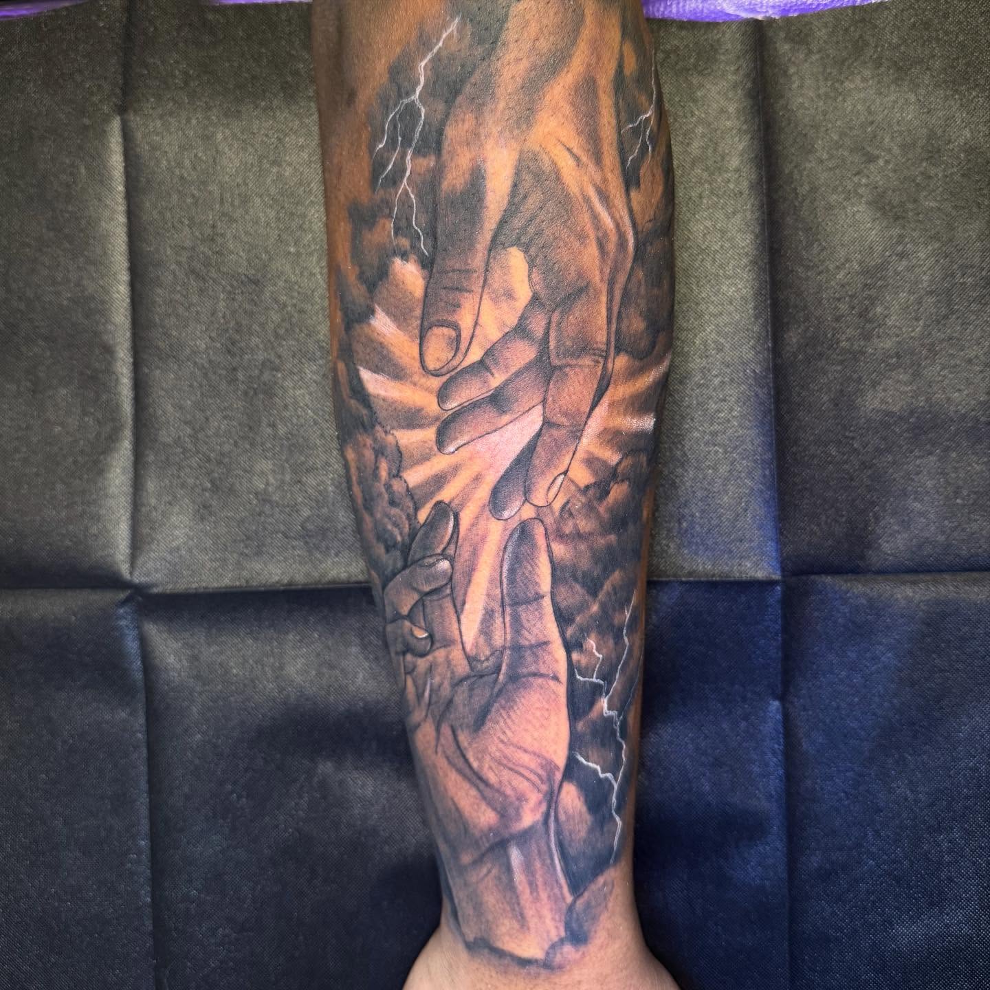 Hands and lightning realism tattoo on the forearm by Justin Weins