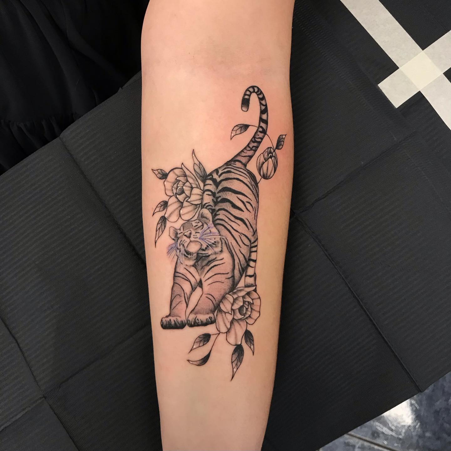 Tiger and flowers black and grey tattoo on the forearm by @artinjections667