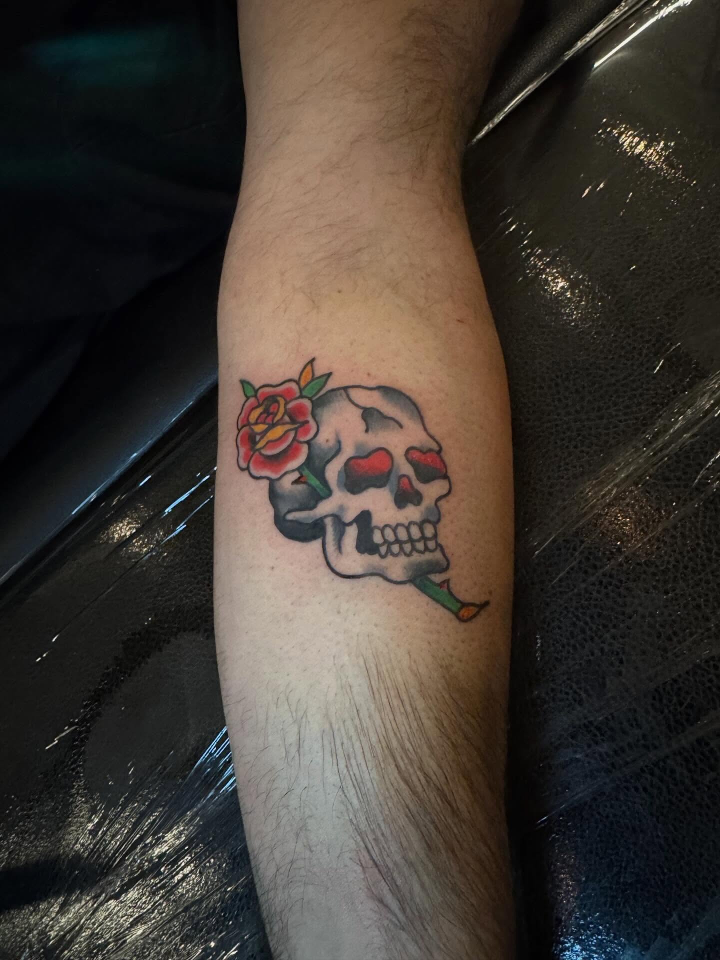 Skull with rose American traditional tattoo on the forearm by Kyle Mitchell, Cincinnati