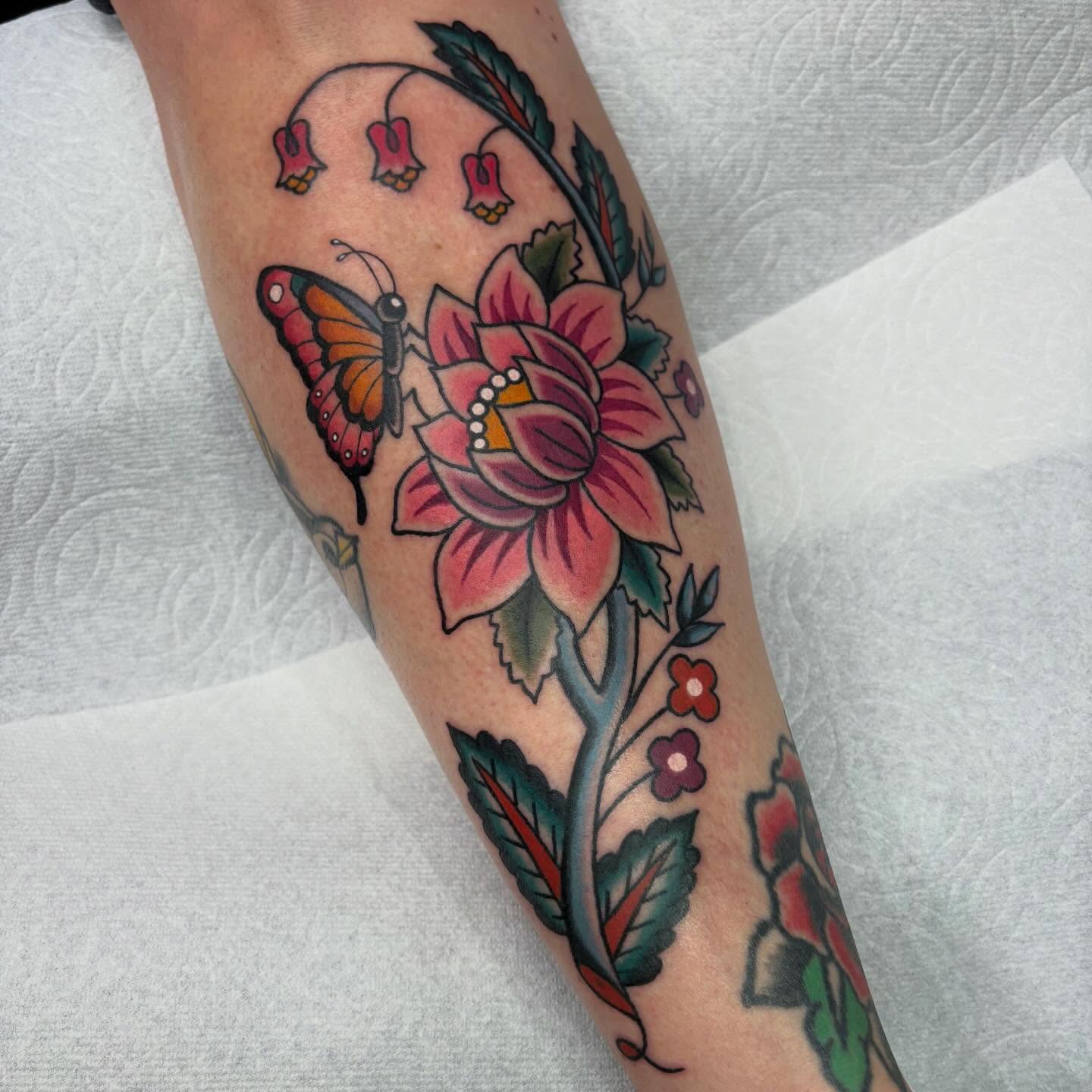 Butterfly and flowers American traditional tattoo on the forearm by Lindsey Cam Van