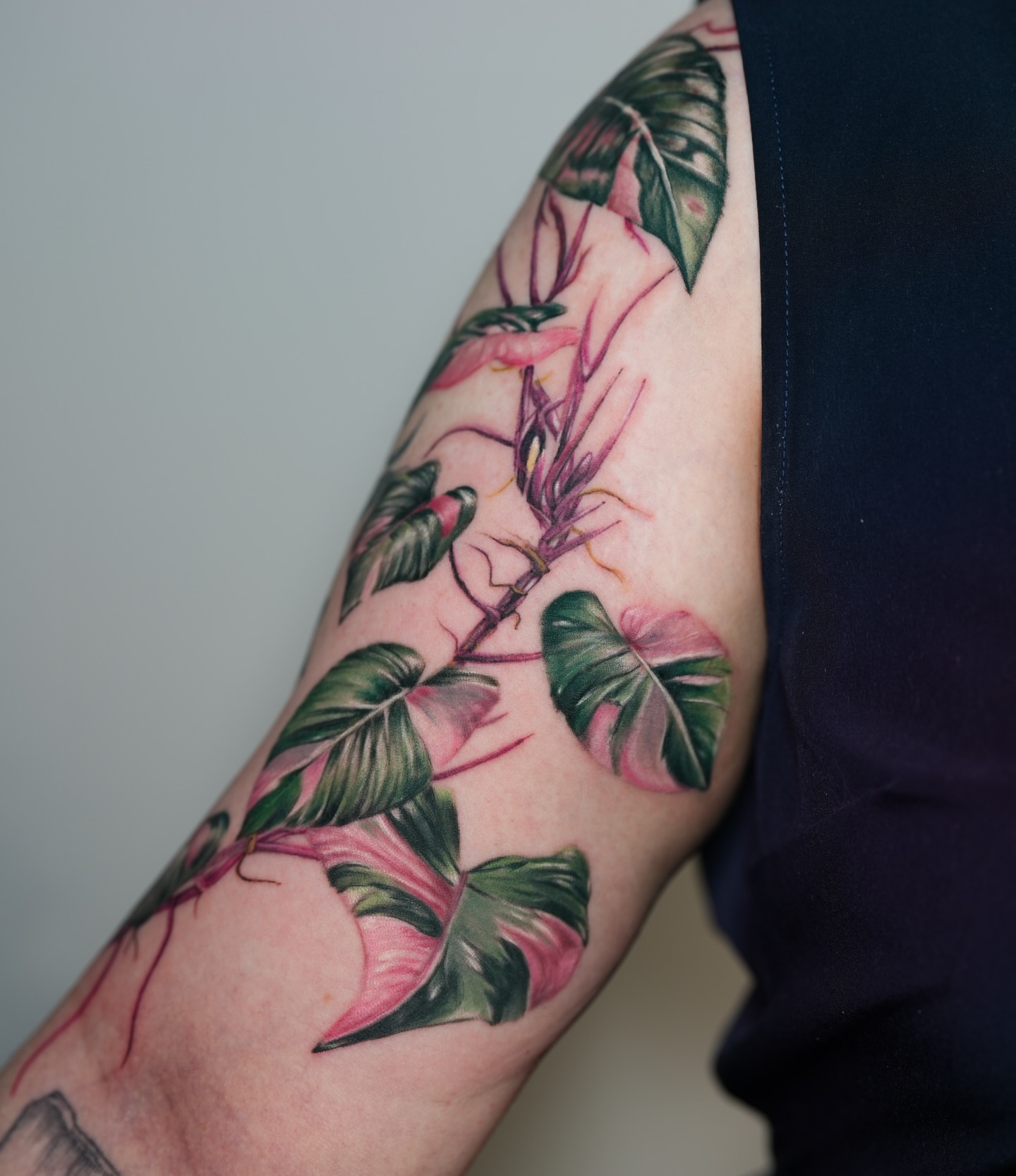Tropical leaves and flowers realism tattoo on the forearm by Henry