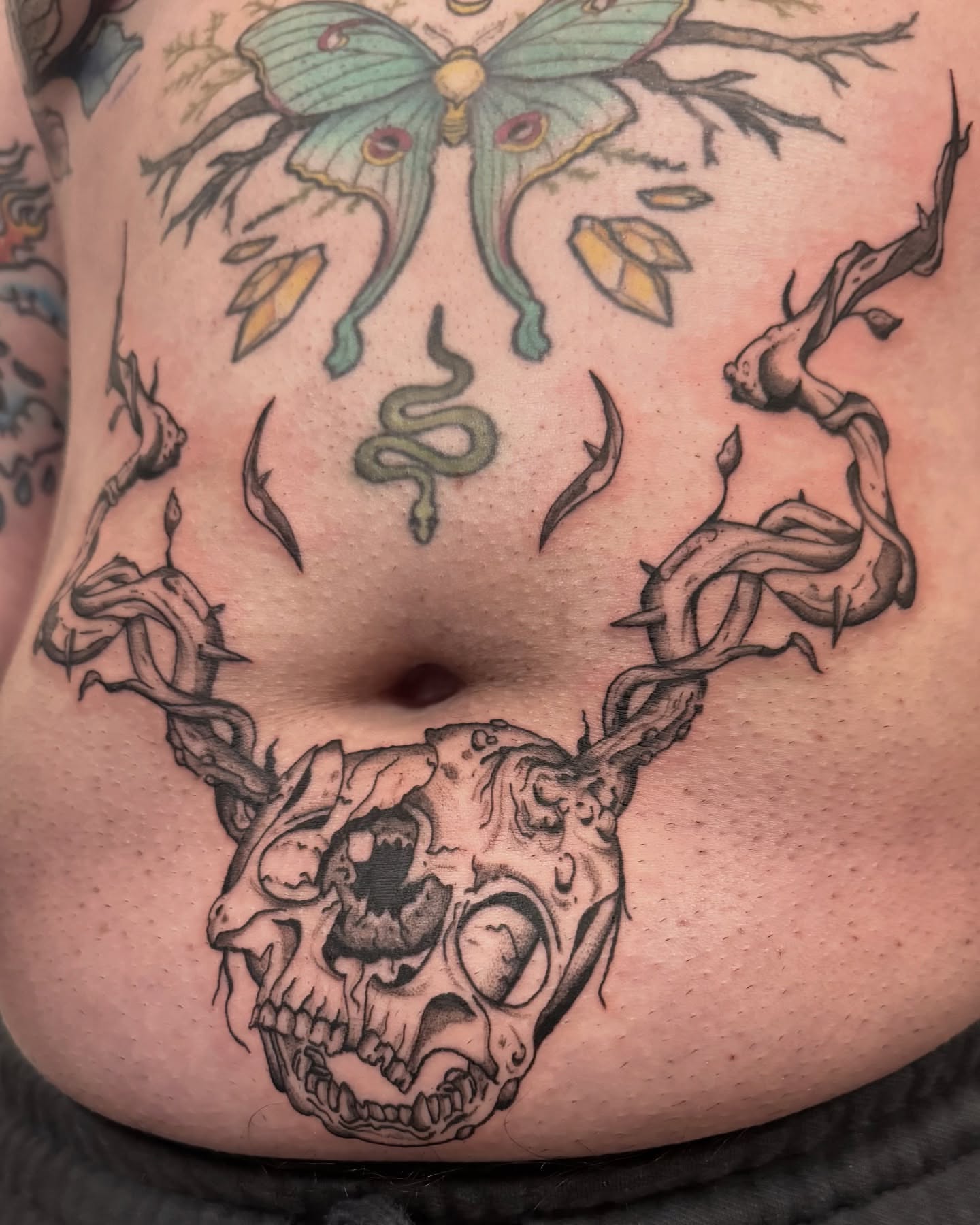 Skull with antlers black and grey tattoo on the torso by jake.inks