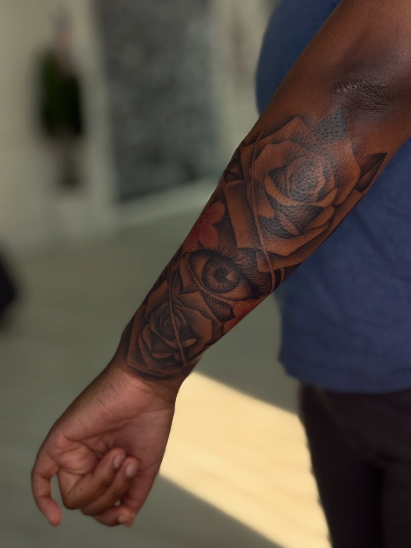 Eye and roses realism tattoo on the forearm by Savannah Tattoo Artist